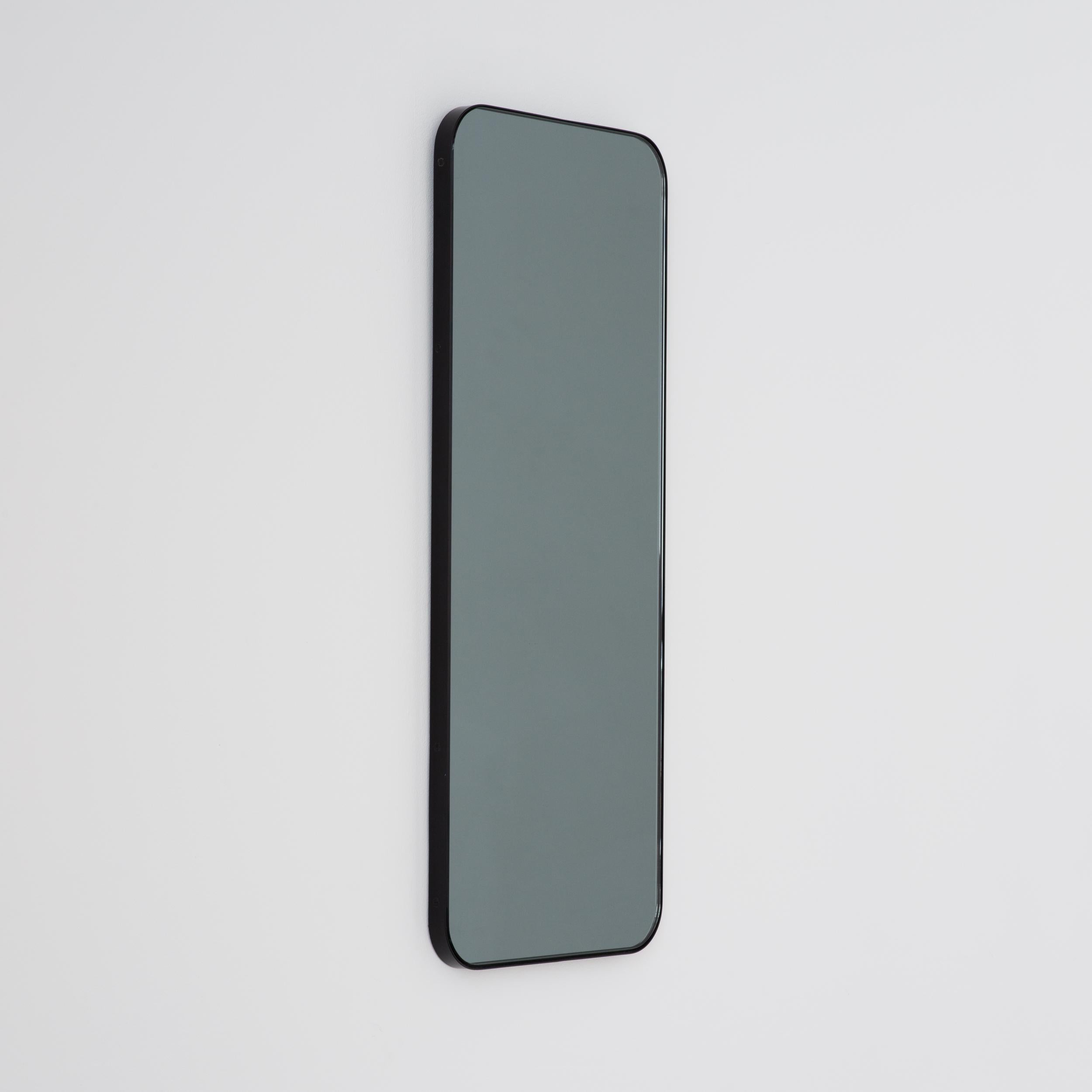 Miroir rectangulaire contemporain teinté noir avec un cadre noir élégant. Une partie de la charmante collection Quadris, conçue et fabriquée à la main à Londres, au Royaume-Uni. 

Fourni avec une barre en z spécialisée pour une installation facile.