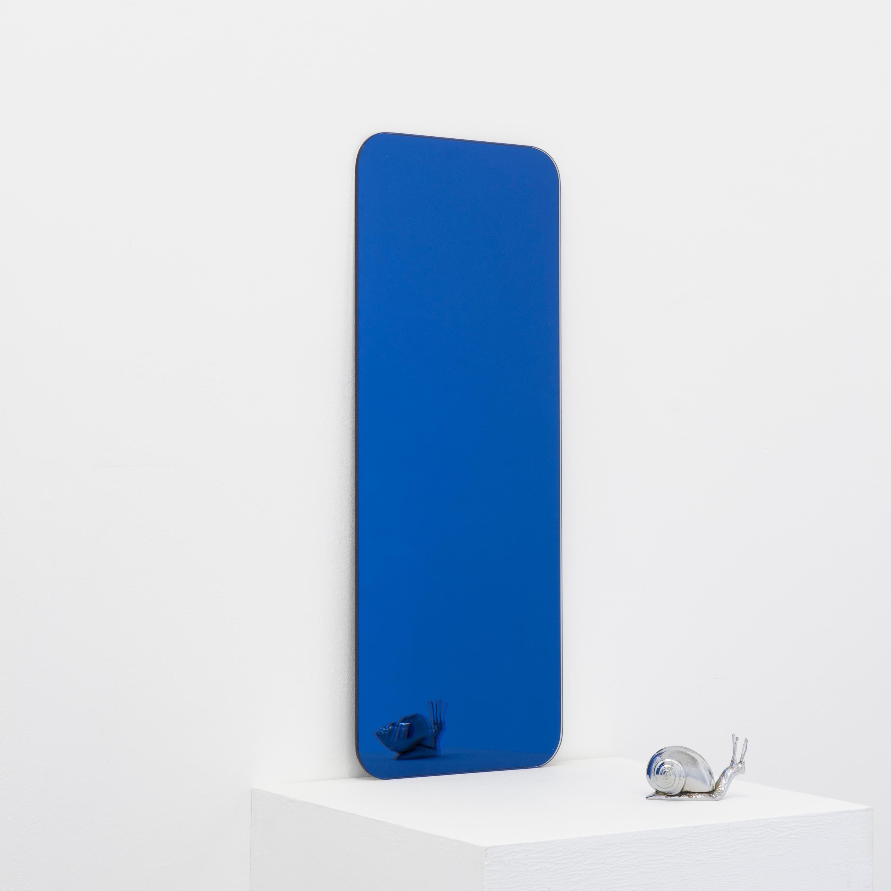 Minimalist rectangular shaped frameless blue tinted mirror with a floating effect. Quality design that ensures the mirror sits perfectly parallel to the wall. Designed and made in London, UK.

Fitted with professional plates not visible once