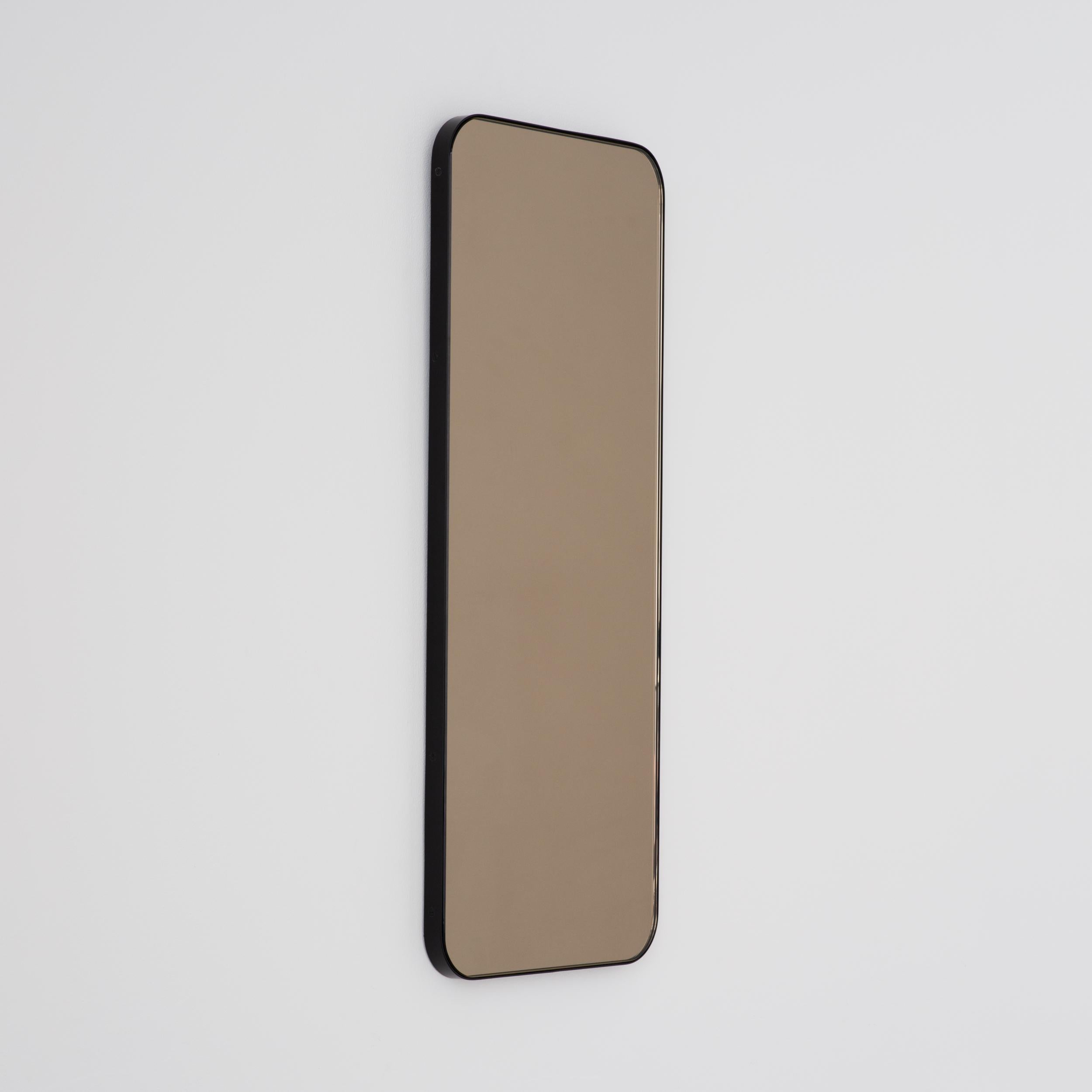 Zeitgenössischer, bronzefarbener, rechteckiger Spiegel mit elegantem schwarzem Rahmen. Teil der charmanten Quadris™ Kollektion, entworfen und handgefertigt in London, UK. 

Die Lieferung erfolgt mit einer speziellen Z-Stange für eine einfache