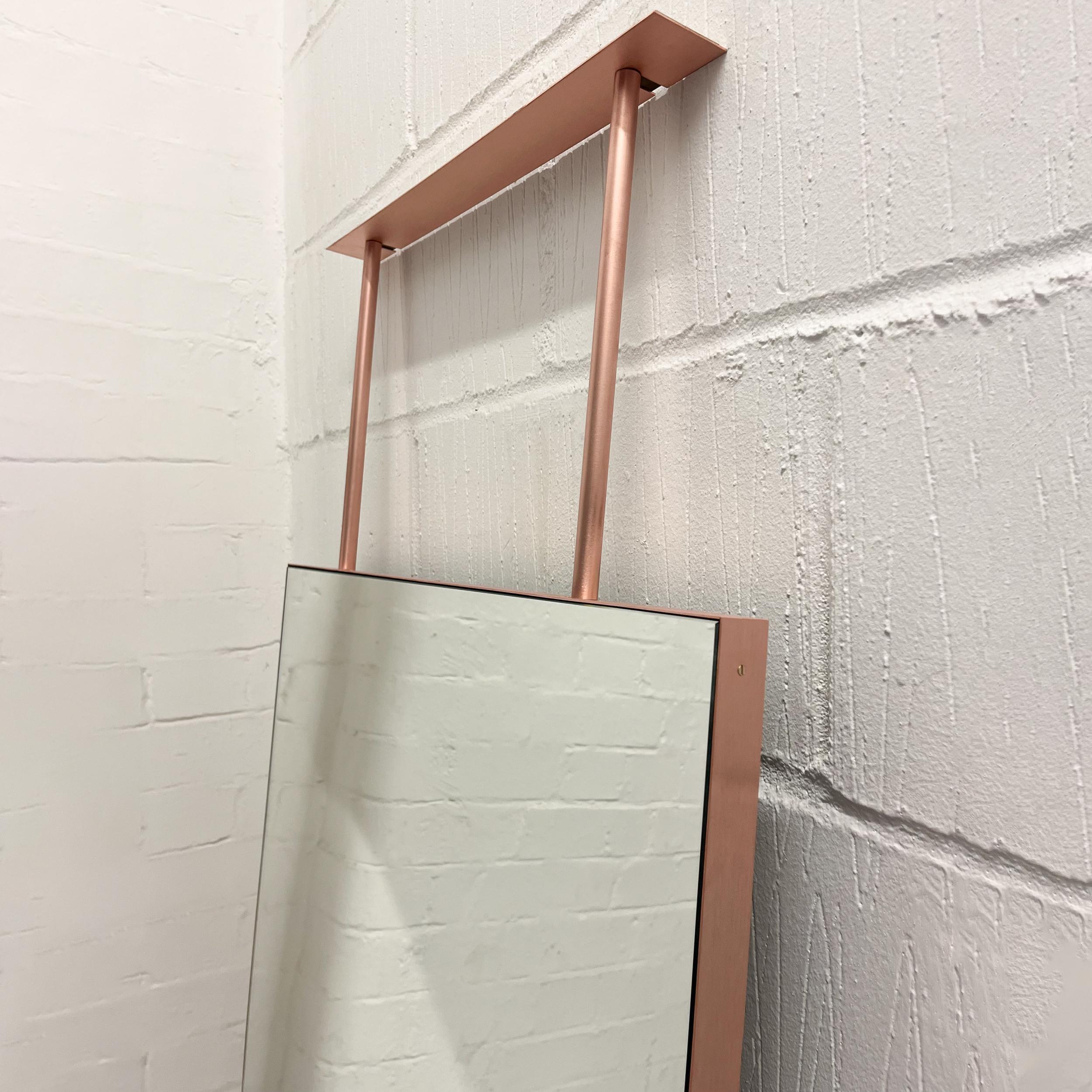Superbe miroir rectangulaire moderne avec un cadre en cuivre.  Cette pièce fait partie de notre collection originale et entièrement personnalisable de miroirs suspendus au plafond, conçus et fabriqués à la main à Londres, au Royaume-Uni. Les détails