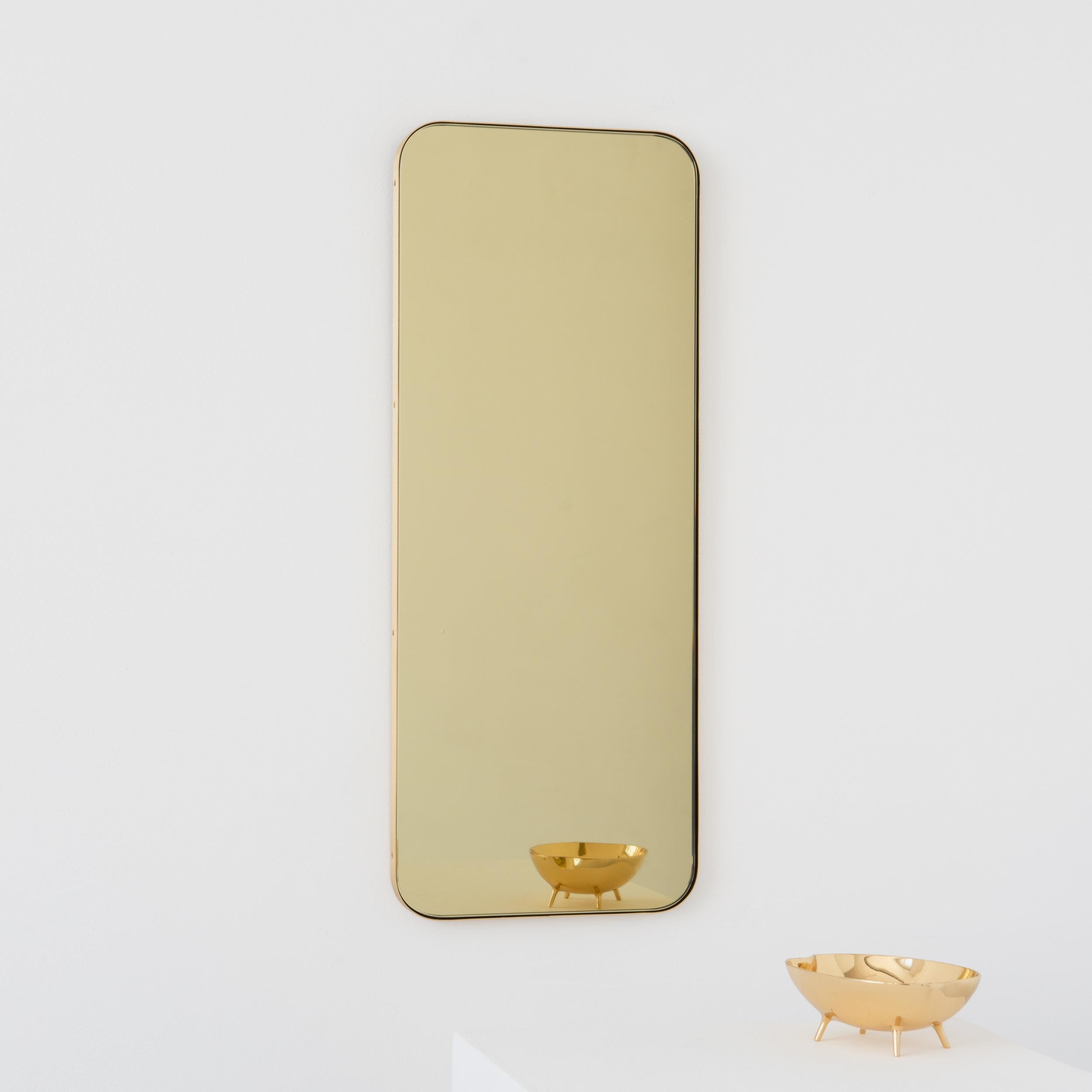 Modern gold tinted rectangular mirror with an elegant solid brushed brass frame. Part of the charming Quadris collection, designed and handcrafted in London, UK. 

Supplied fitted with a specialist z-bar for an easy installation. A split batten