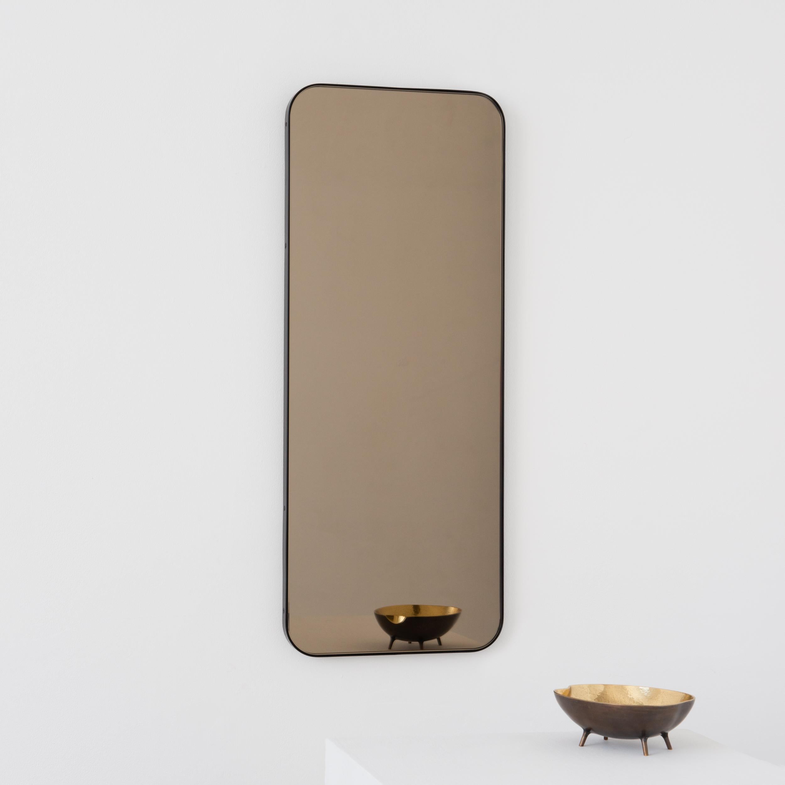 Modern rectangular mirror with an elegant solid bronze patina brass frame. Part of the charming Quadris collection, designed and handcrafted in London, UK. 

Supplied fitted with a specialist z-bar for an easy installation. A split batten hanging