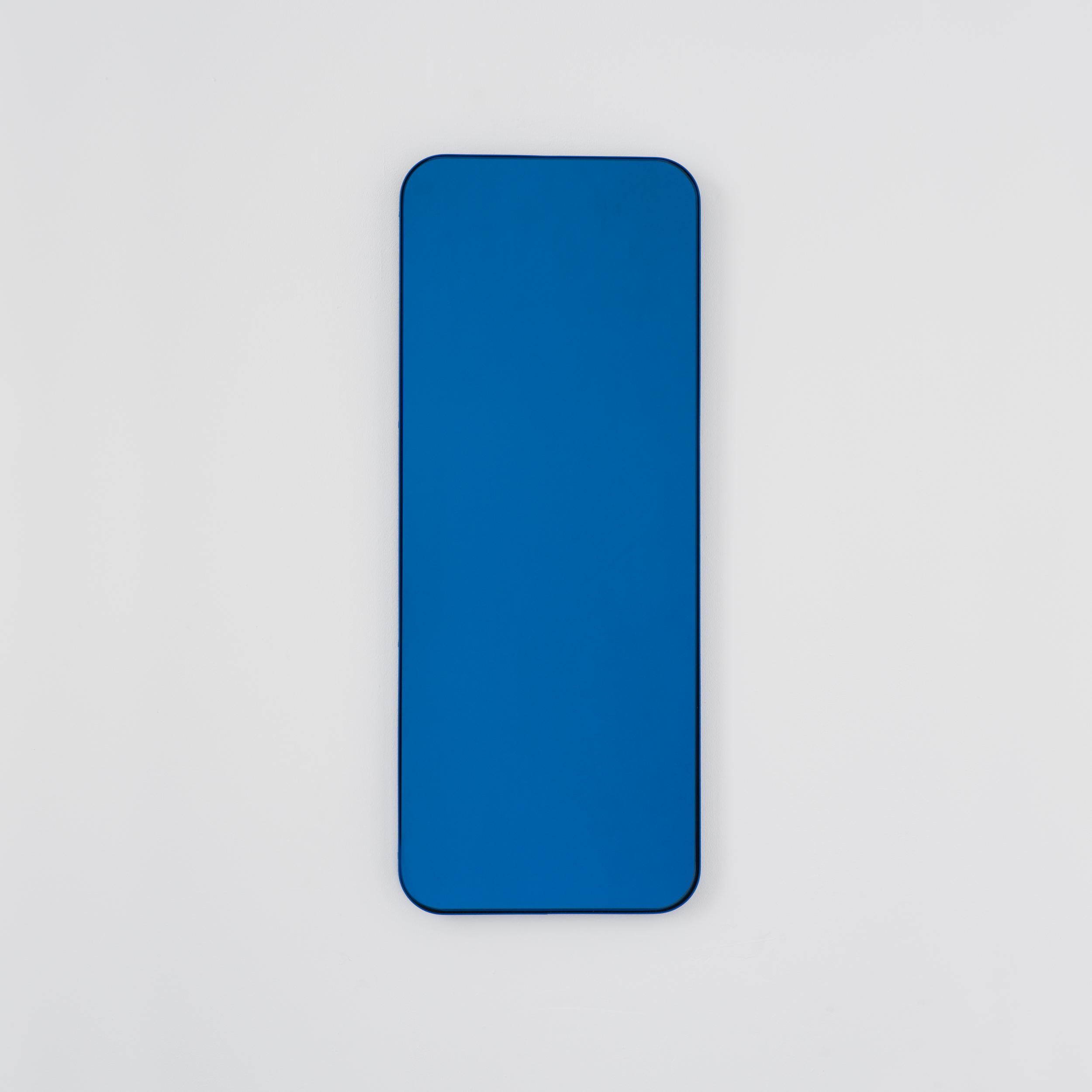 Moderner rechteckiger Spiegel mit einem eleganten blauen Rahmen. Teil der charmanten Quadris Collection, entworfen und handgefertigt in London, UK. 

Die Lieferung erfolgt mit einer speziellen Z-Stange für eine einfache Installation. Auf Anfrage
