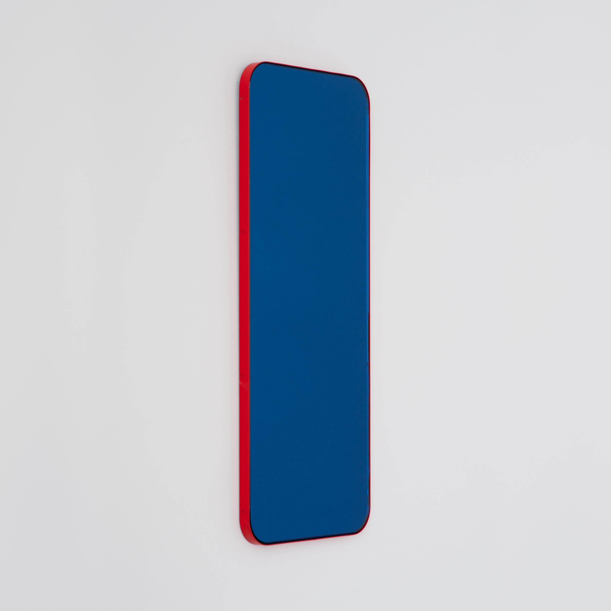 Miroir rectangulaire contemporain teinté de bleu avec un cadre rouge moderne. Une partie de la charmante collection Quadris™, conçue et fabriquée à la main à Londres, au Royaume-Uni. 

Fourni avec une barre en z spécialisée pour une installation