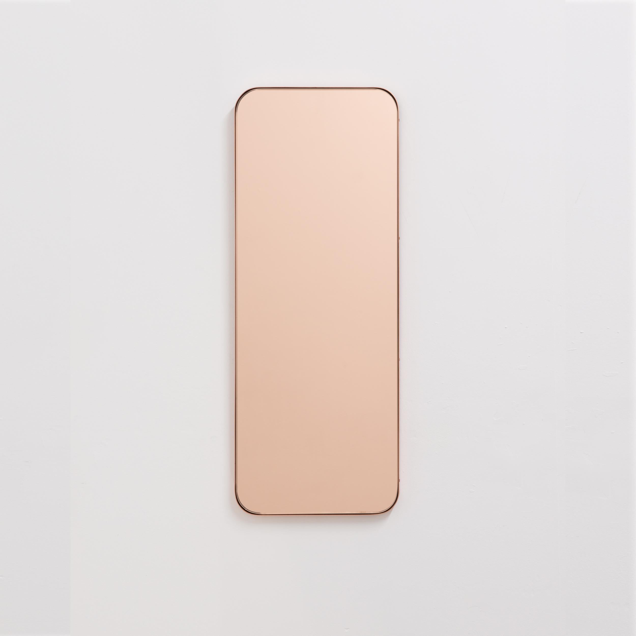 Miroir rectangulaire minimaliste avec un élégant cadre fin en cuivre brossé. Les détails et la finition, y compris les vis visibles plaquées cuivre, soulignent l'aspect artisanal et la qualité du miroir, véritable signature de notre marque. Conçu et