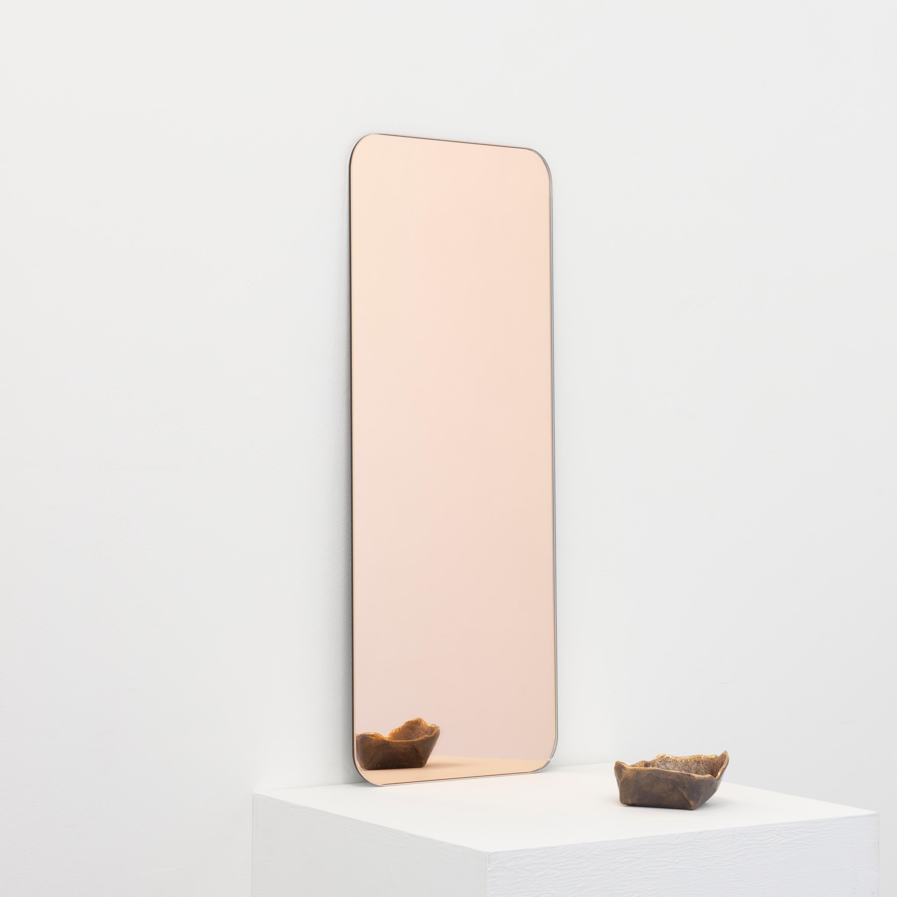 Minimalist rectangular shaped frameless rose gold tinted mirror with a floating effect. Quality design that ensures the mirror sits perfectly parallel to the wall. Designed and made in London, UK.

Fitted with professional plates not visible once