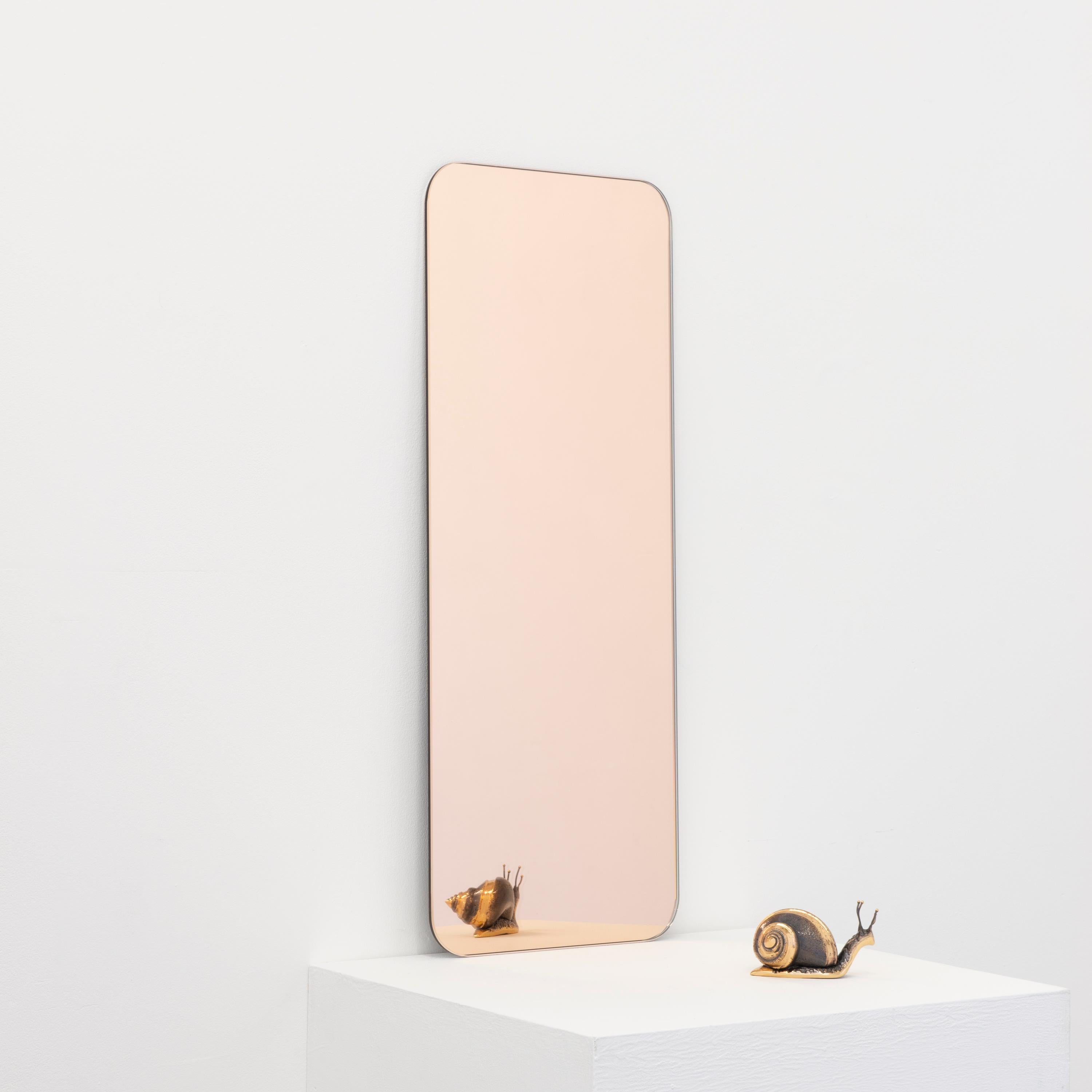 Minimalist rectangular shaped frameless rose gold tinted mirror with a floating effect. Quality design that ensures the mirror sits perfectly parallel to the wall. Designed and made in London, UK.

Fitted with professional plates not visible once