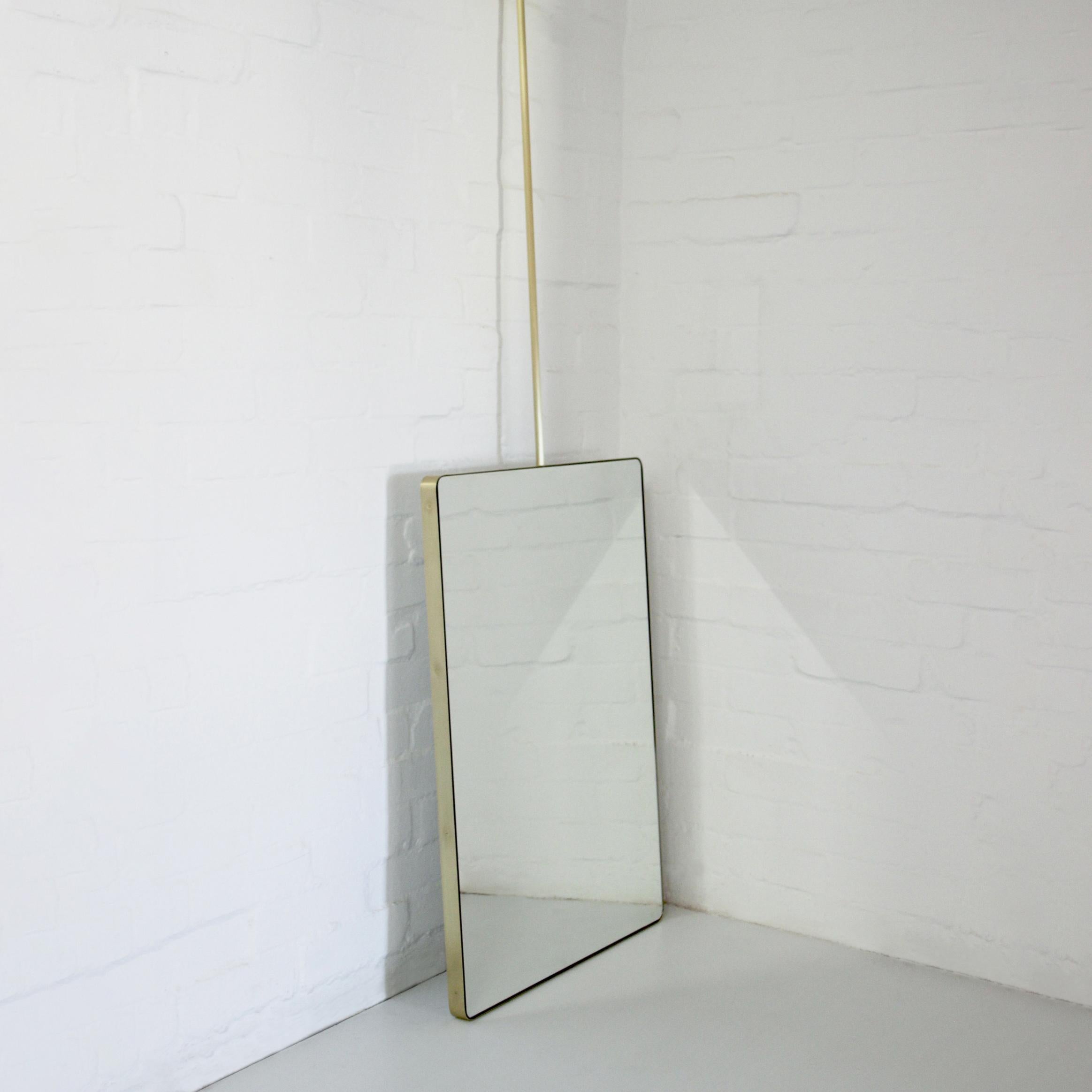 Miroir rectangulaire unique et moderne suspendu au plafond, doté d'un cadre élégant en laiton brossé massif et d'un dos lisse en aluminium blanc.

559mm (22