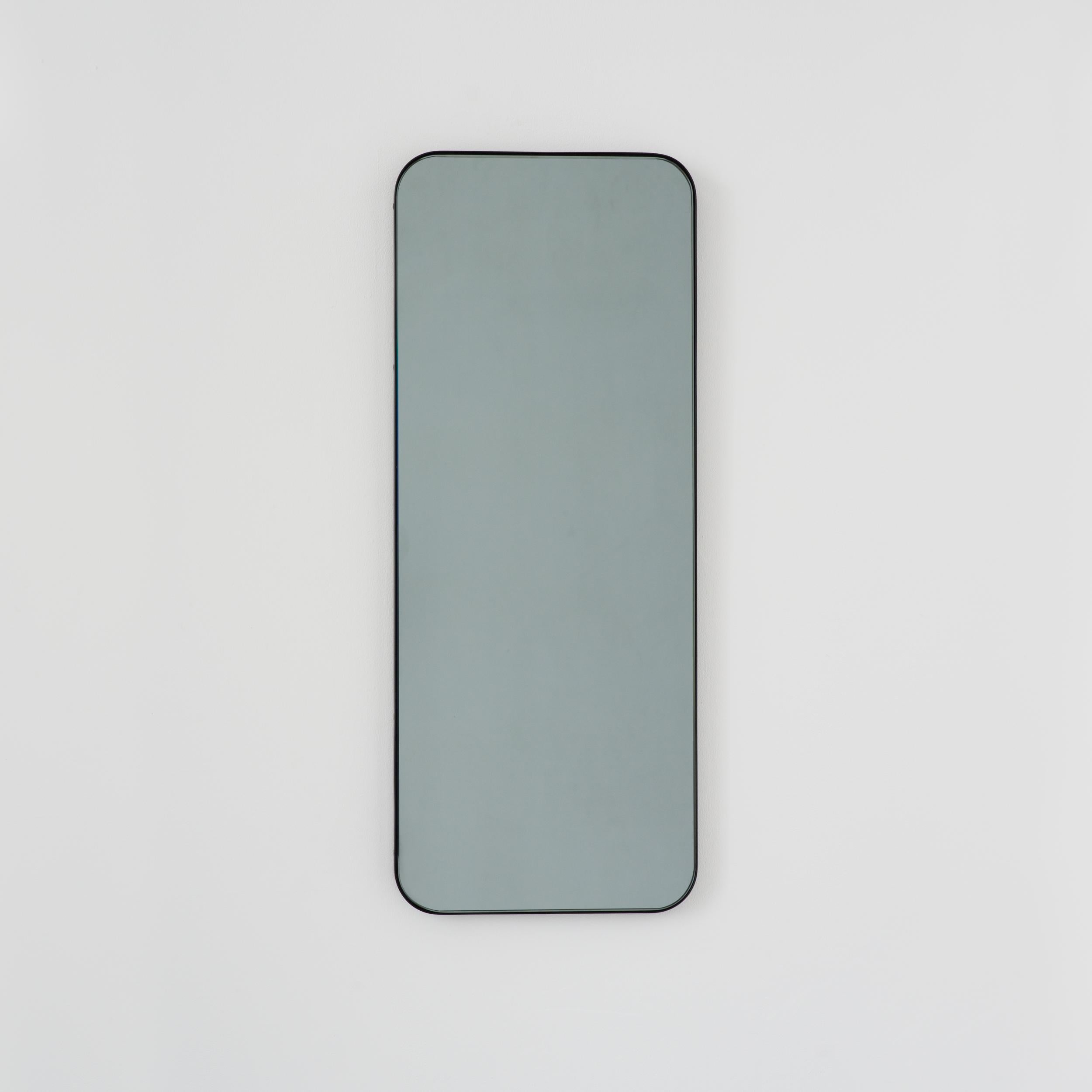 Miroir rectangulaire contemporain teinté noir avec un cadre noir élégant. Une partie de la charmante collection Quadris™, conçue et fabriquée à la main à Londres, au Royaume-Uni. 

Fourni avec une barre en z spécialisée pour une installation facile.