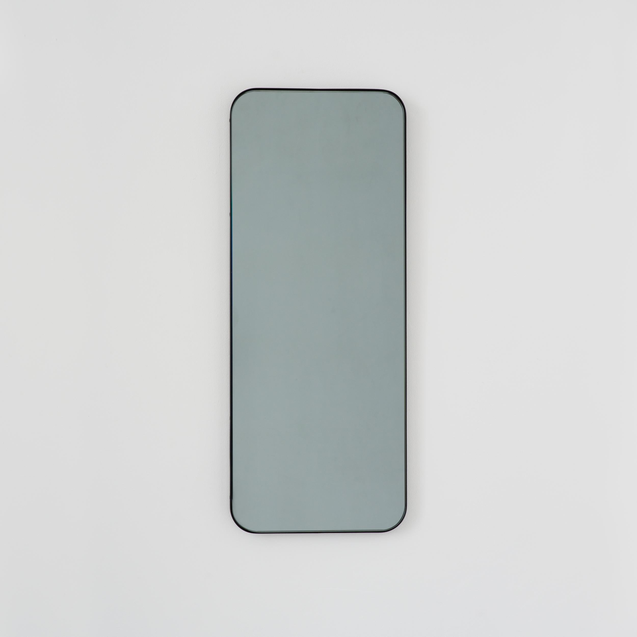 Miroir rectangulaire contemporain teinté noir avec un cadre noir élégant. Une partie de la charmante collection Quadris, conçue et fabriquée à la main à Londres, au Royaume-Uni. 

Fourni avec une barre en z spécialisée pour une installation facile.