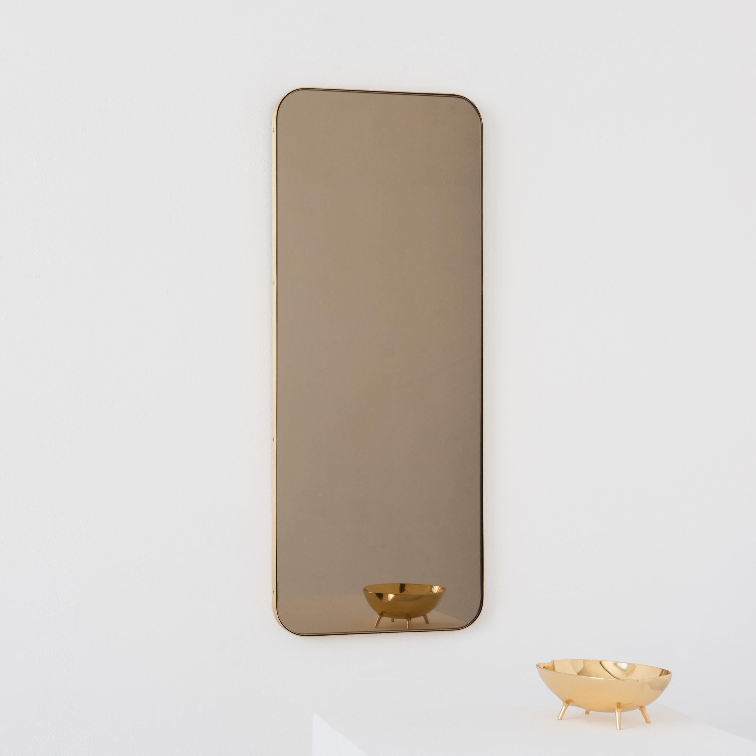 Moderner, bronzefarben getönter, rechteckiger Spiegel mit einem eleganten Rahmen aus gebürstetem Messing. Teil der charmanten Quadris Kollektion, entworfen und handgefertigt in London, UK. 

Unsere Spiegel sind mit einem integrierten französischen