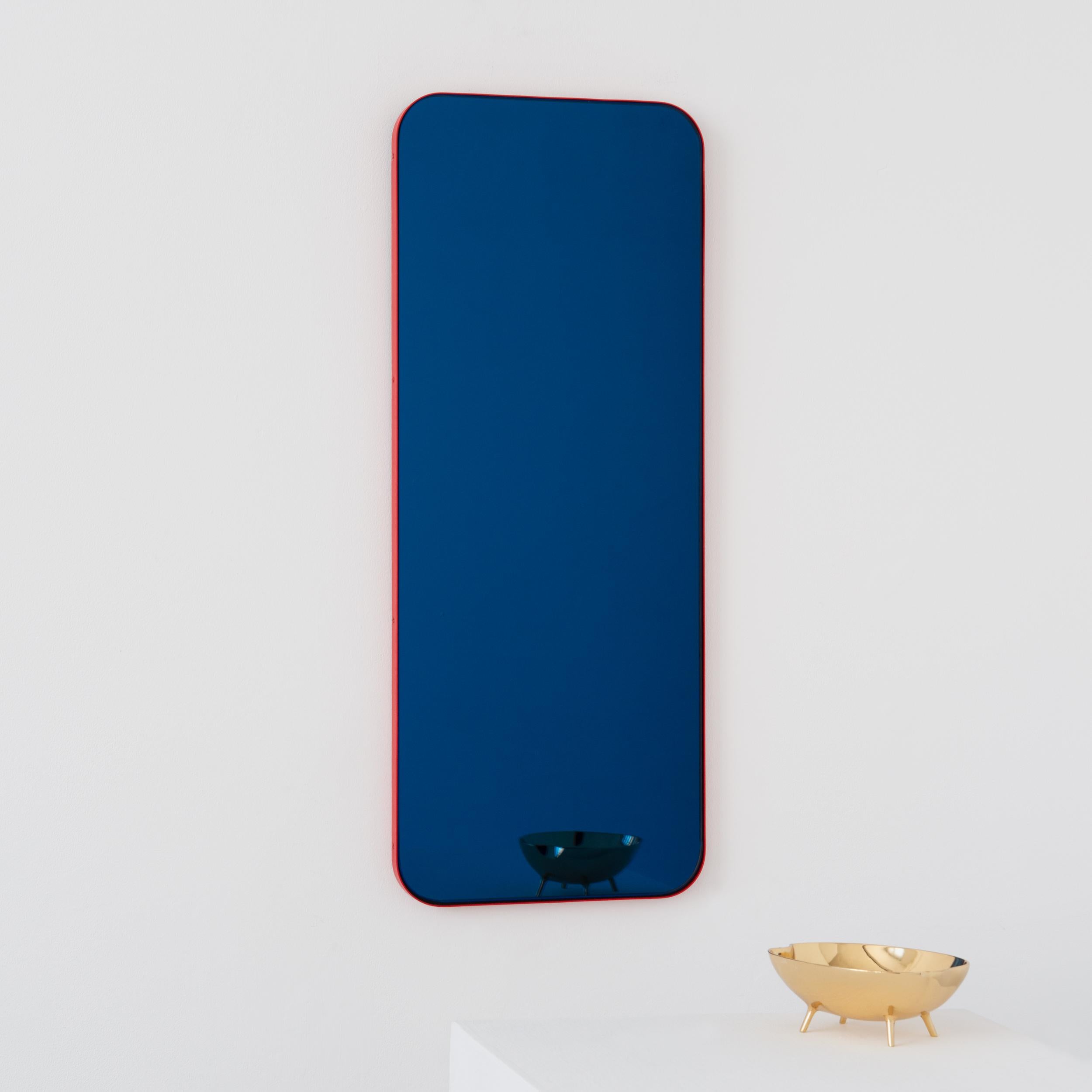 Miroir rectangulaire contemporain teinté de bleu avec un cadre rouge moderne. Une partie de la charmante collection Quadris, conçue et fabriquée à la main à Londres, au Royaume-Uni. 

Fourni avec une barre en z spécialisée pour une installation