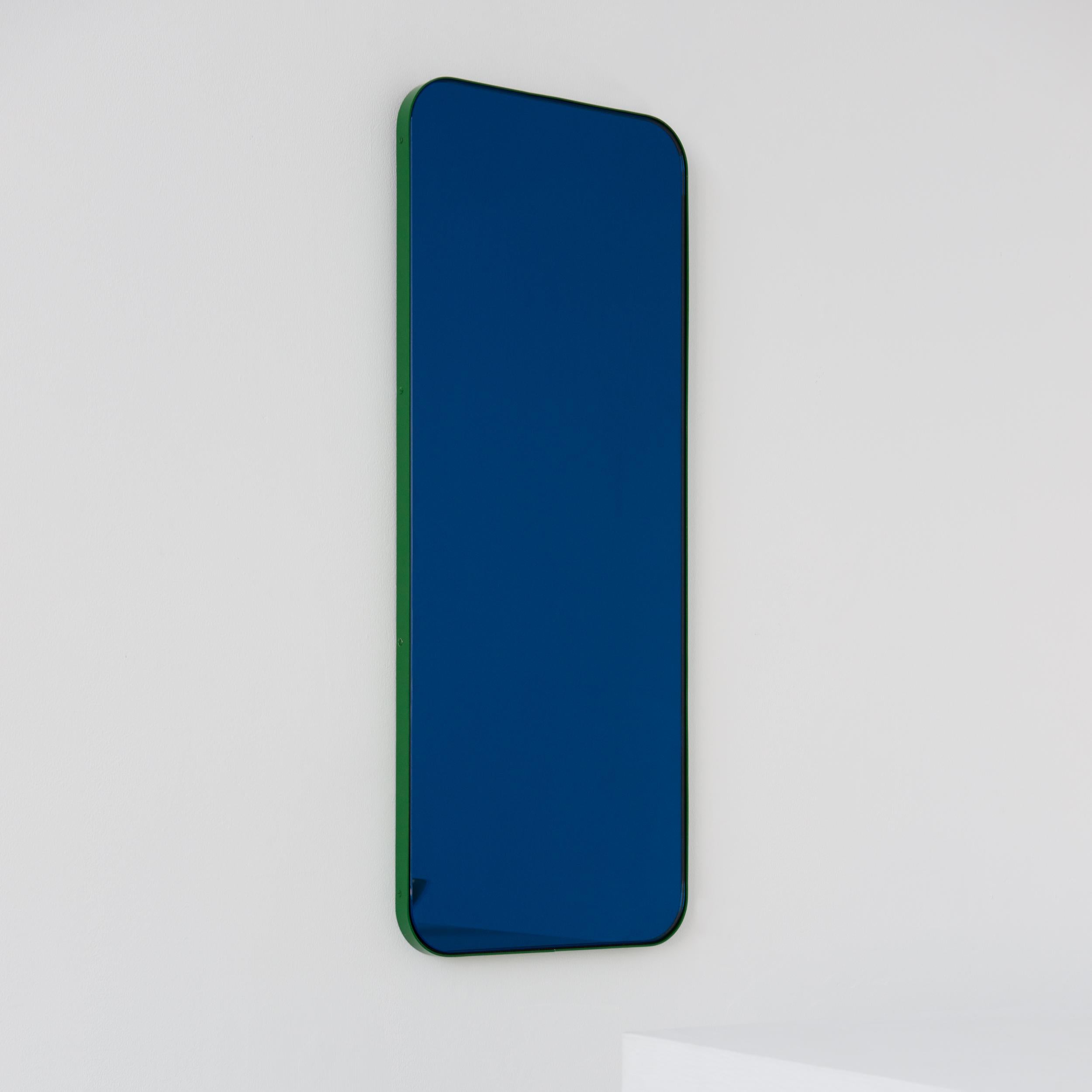 Modern rectangular blue tinted mirror with a contemporary green frame. Part of the charming Quadris™ collection, designed and handcrafted in London, UK. 

Supplied fitted with a specialist z-bar for an easy installation. A split batten hanging