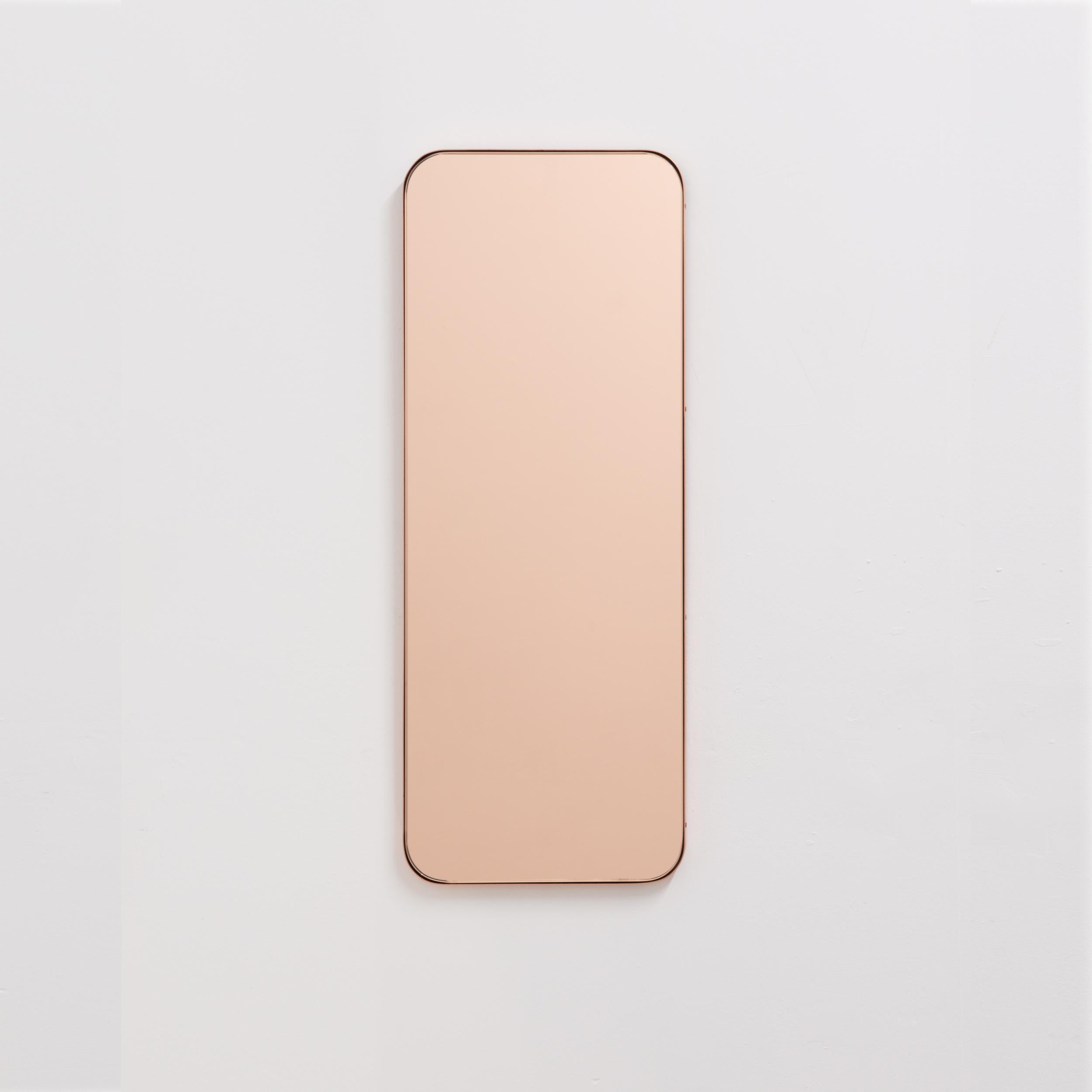 Specchio rettangolare minimalista con un'elegante cornice sottile in rame spazzolato. I dettagli e le finiture, comprese le viti placcate in rame a vista, sottolineano la sensazione di artigianalità e qualità dello specchio, una vera e propria firma