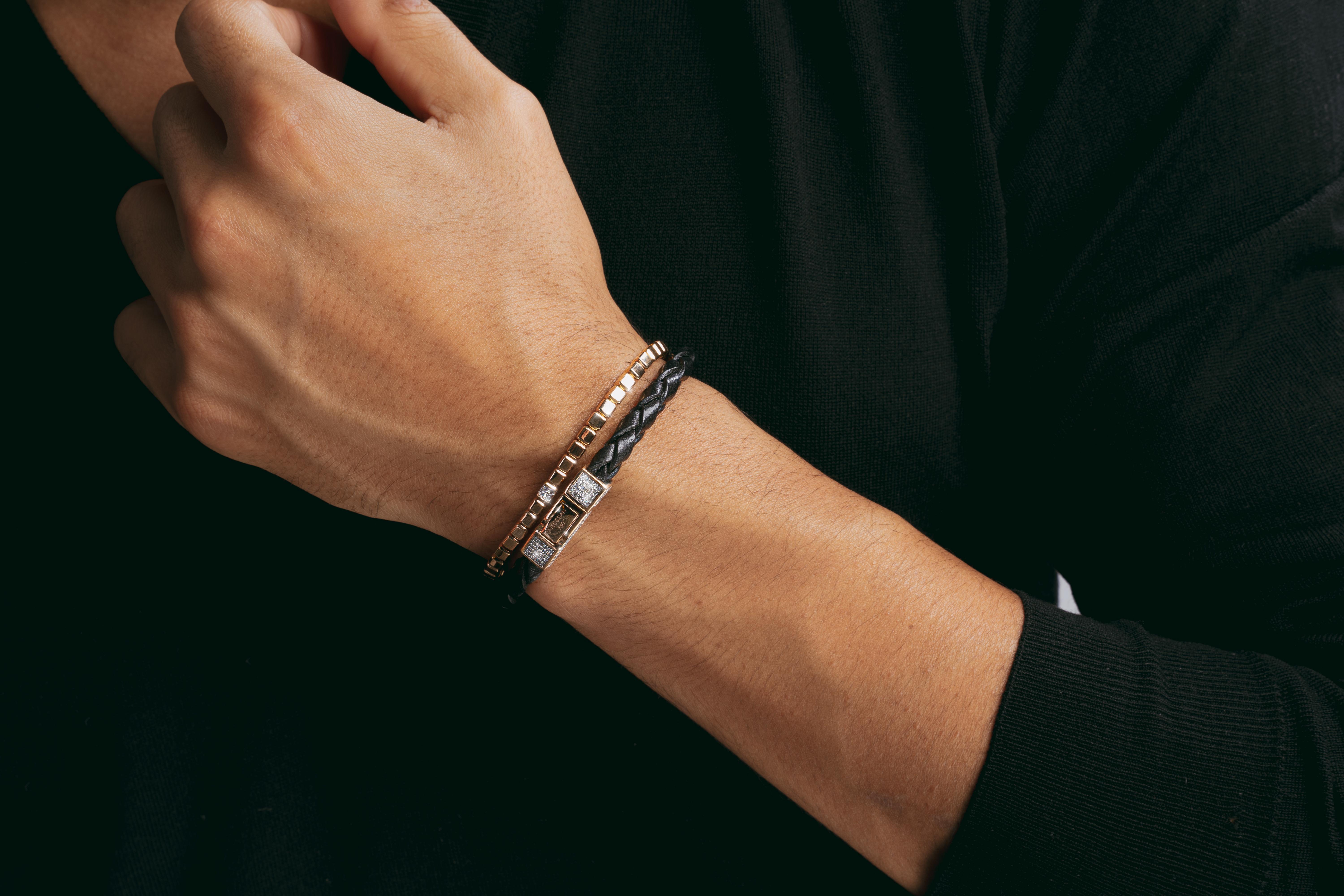 Delicate yet distinctive, this 18K rose gold bracelet features an inner elastic concealed with small cubes of 18carat gold. A single, central cube adds sparkle, studded with pave black diamonds on all four sides for a stylish look. Available in