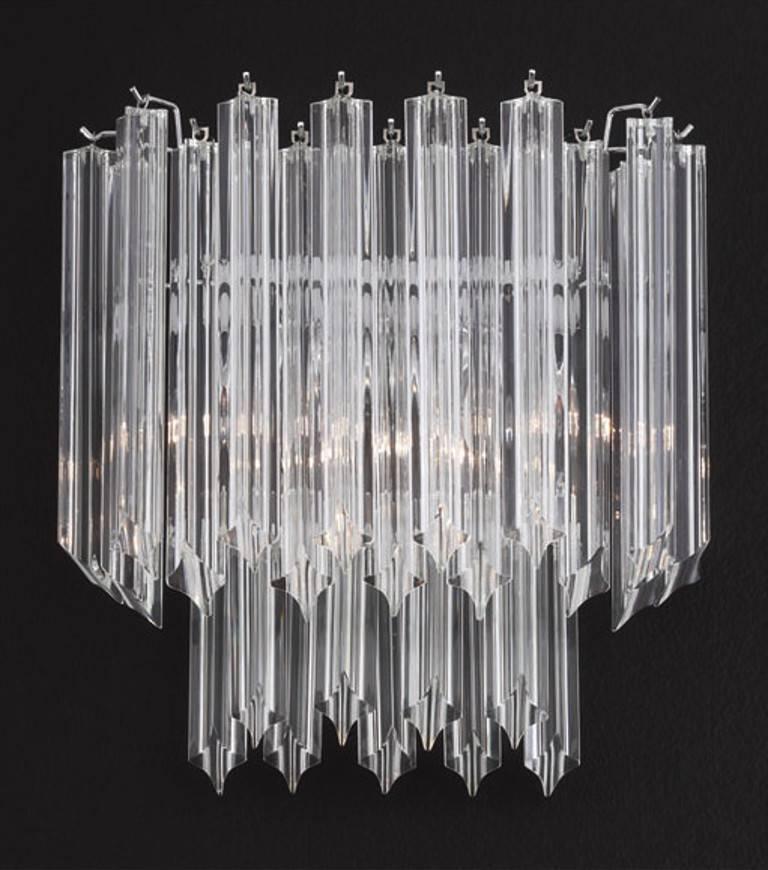 Aplique italiano con cristales de Murano transparentes soplados a mano en cuatro puntas mediante la técnica Quadriedri, montado en un marco de metal cromado, diseñado por Fabio Bergomi, fabricado en Italia.
3 luces / tipo E12 o E14 / máx. 40W cada