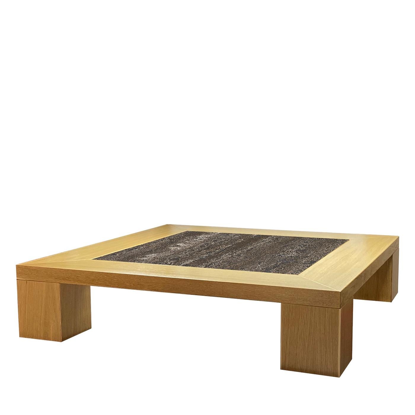 A restrained, clean-cut durmast frame traces the silhouette of this coffee table, an exquisite piece for complementing refined modern decors. The characteristic element is the intriguing top inlay in Titanium marble, which strikes with its deep