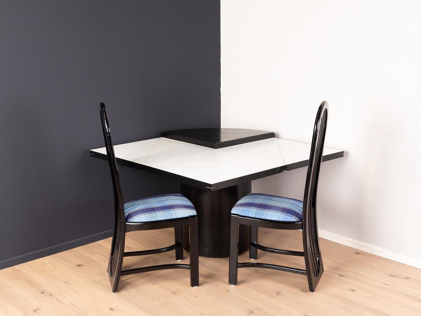 Quadrondo dining table from the 1980s by Erwin Nagel for Rosenthal Einrichtung. High-quality construction consisting of a round base and a table top in black stained ash veneer. By unfolding each quarter, the round table top can be converted into a
