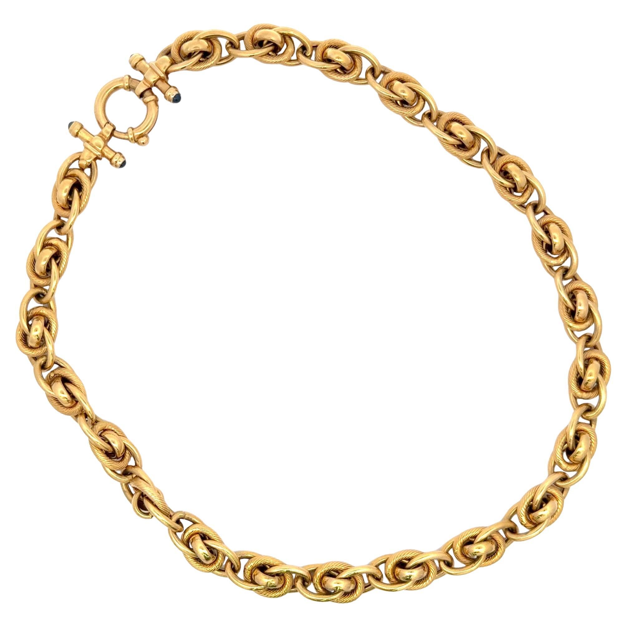 Diese in Italien gefertigte Halskette aus 14 Karat Gelbgold besteht aus 4 ineinandergreifenden Gliedern mit 36 Gramm, einem Knebelverschluss und 4 Cabochon-Saphiren. Passendes Armband auf Lager. 