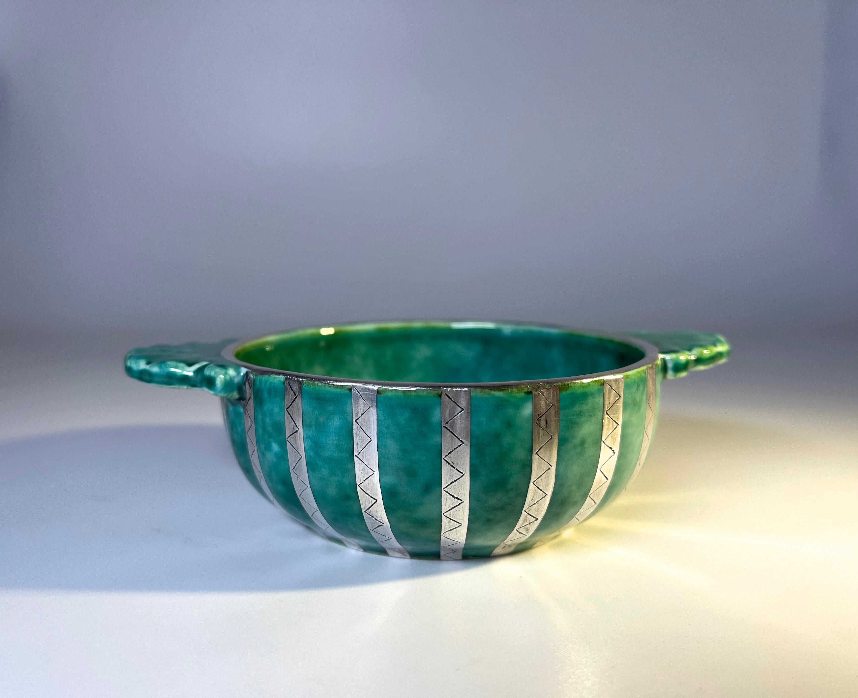 Beautiful stoneware quaich two handled loving cup from the Argenta collection by Wilhelm Kage for Gustavsberg, Sweden
This wonderful traditional wedding cup is decorated with applied silver etched stripes around the entire exterior, with plain