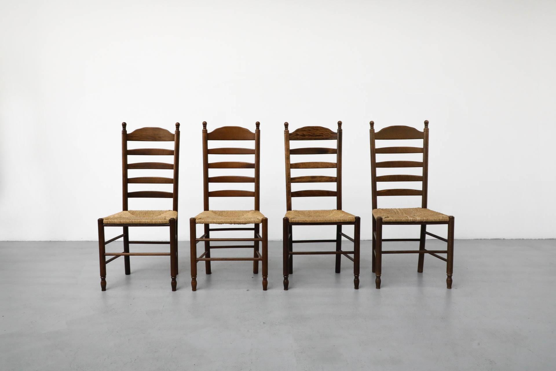 Quaker style dining chairs with hand-woven rush seats. 2 available in a reddish hue. In lightly refinished condition with age appropriate wear to frame and seating. Sold individually.