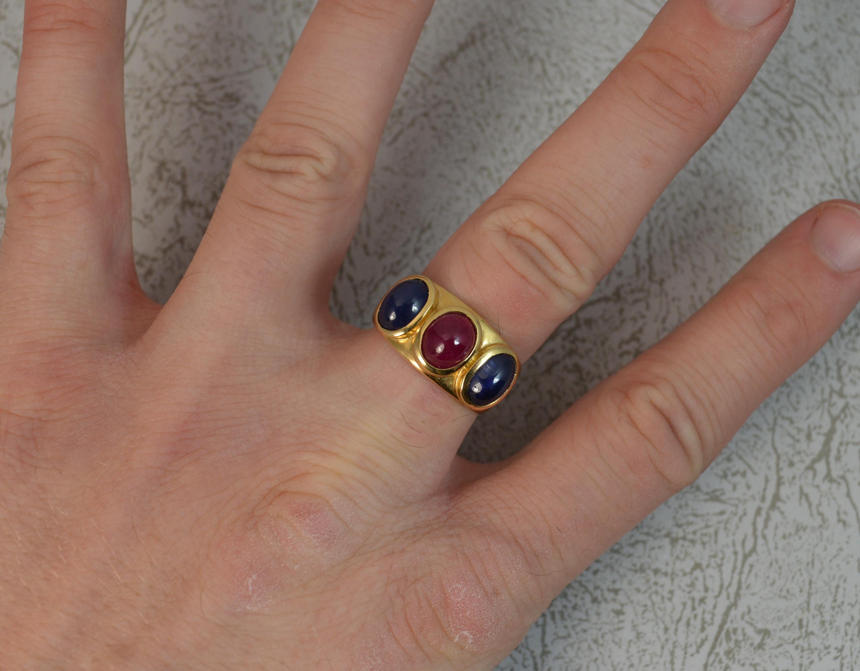 A fantastic Ruby and Sapphire three stone ring.
Solid 18 carat yellow gold example with fine bezel settings.
6.3mm x 8mm ruby. 6mm x 8mm sapphires. Approx.
19mm spread of stones. 10.5mm wide band.

CONDITION ; Excellent. Clean and solid band. Well