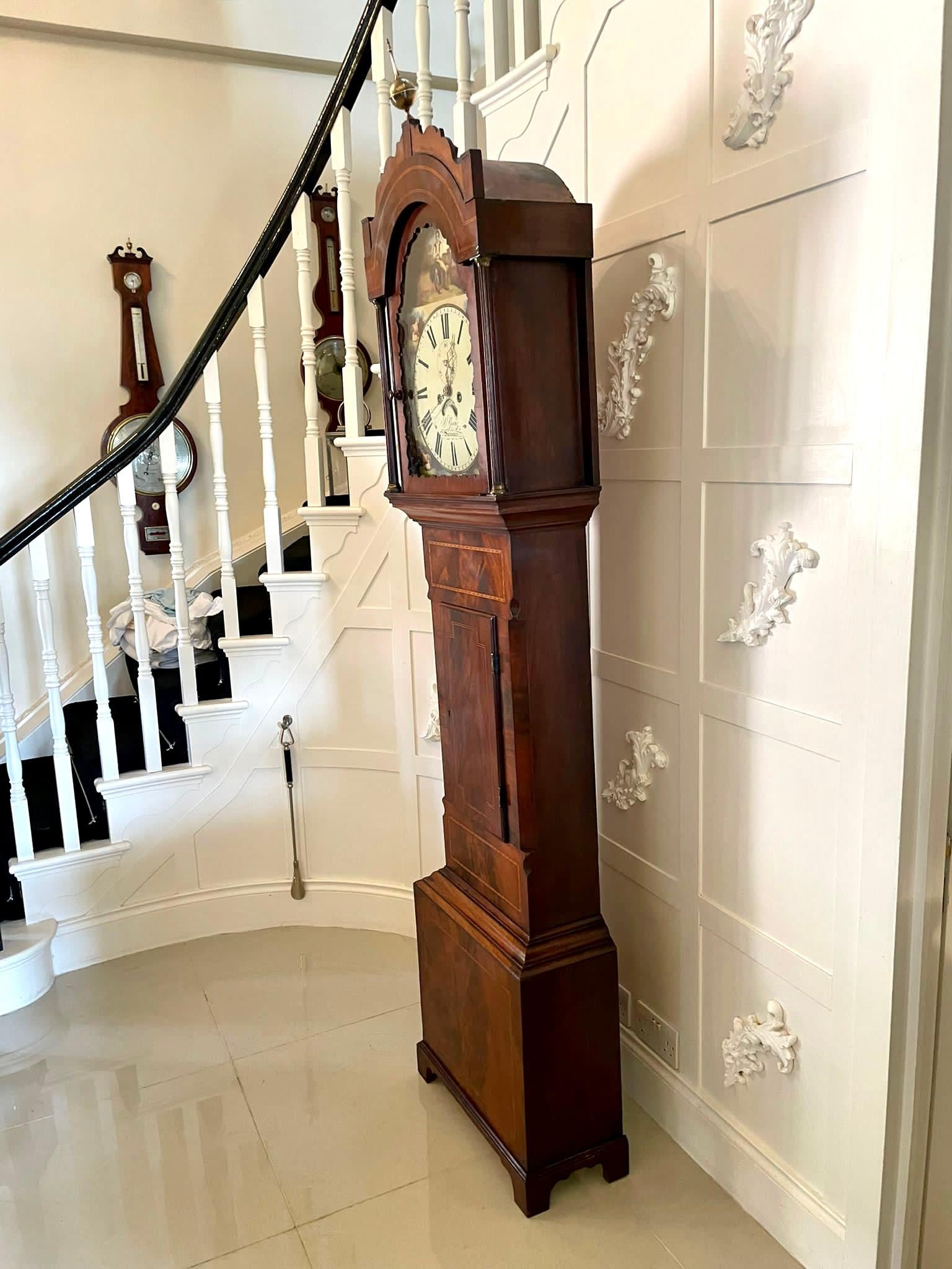 Quality 19th century antique mahogany inlaid eight day longcase clock by Ganz of Swansea having a quality mahogany case with a wavy pediment and arched glazed door flanked by reeded pilasters. It boasts a pretty painted arched dial depicting a young