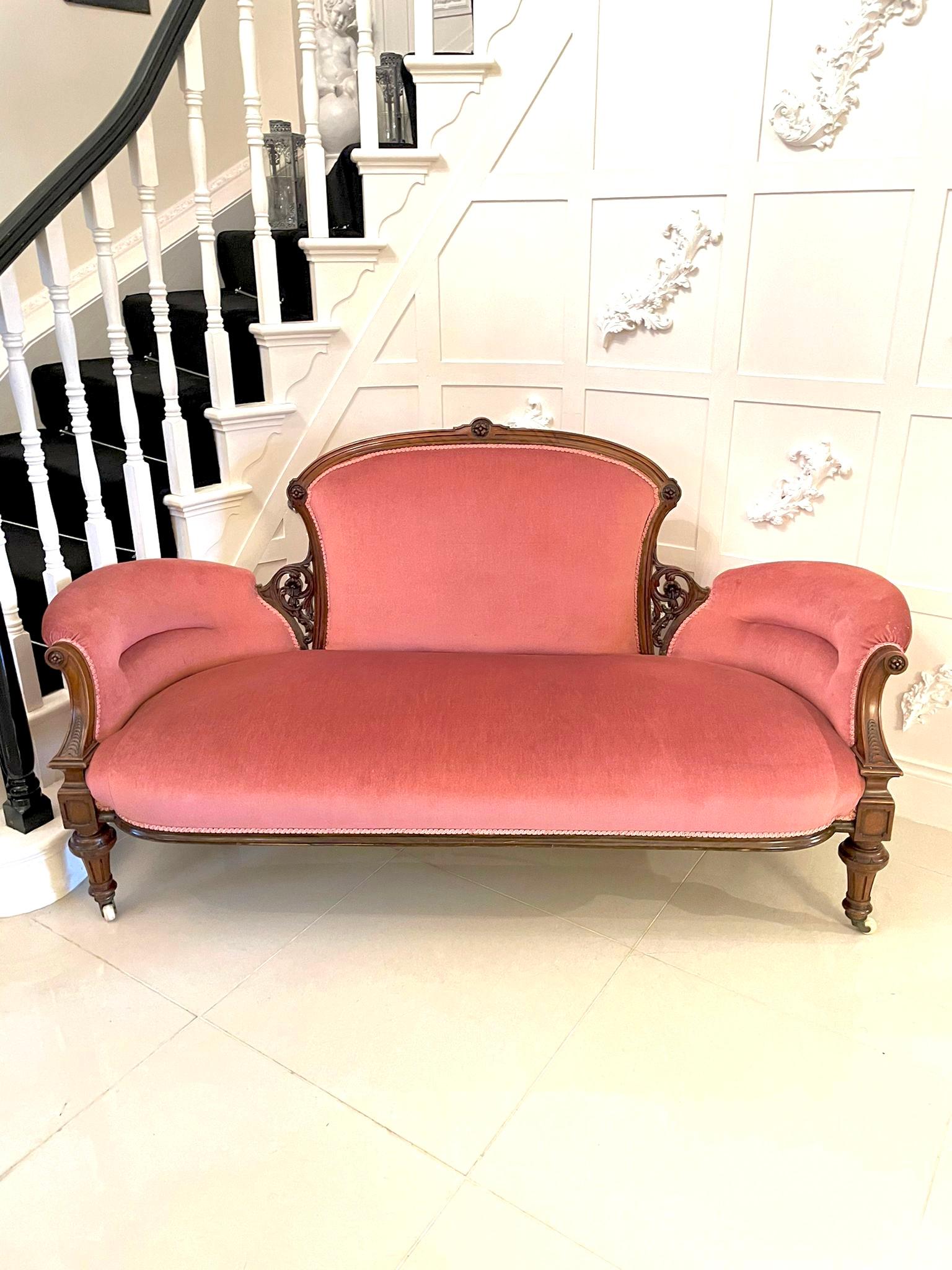Quality 19th century antique Victorian walnut settee having a quality solid walnut carved shaped frame raised on turned reeded legs to the front out swept back with original casters, upholstered in pink fabric. 

H 95cm 
W 167.5cm 
D 69cm
H to