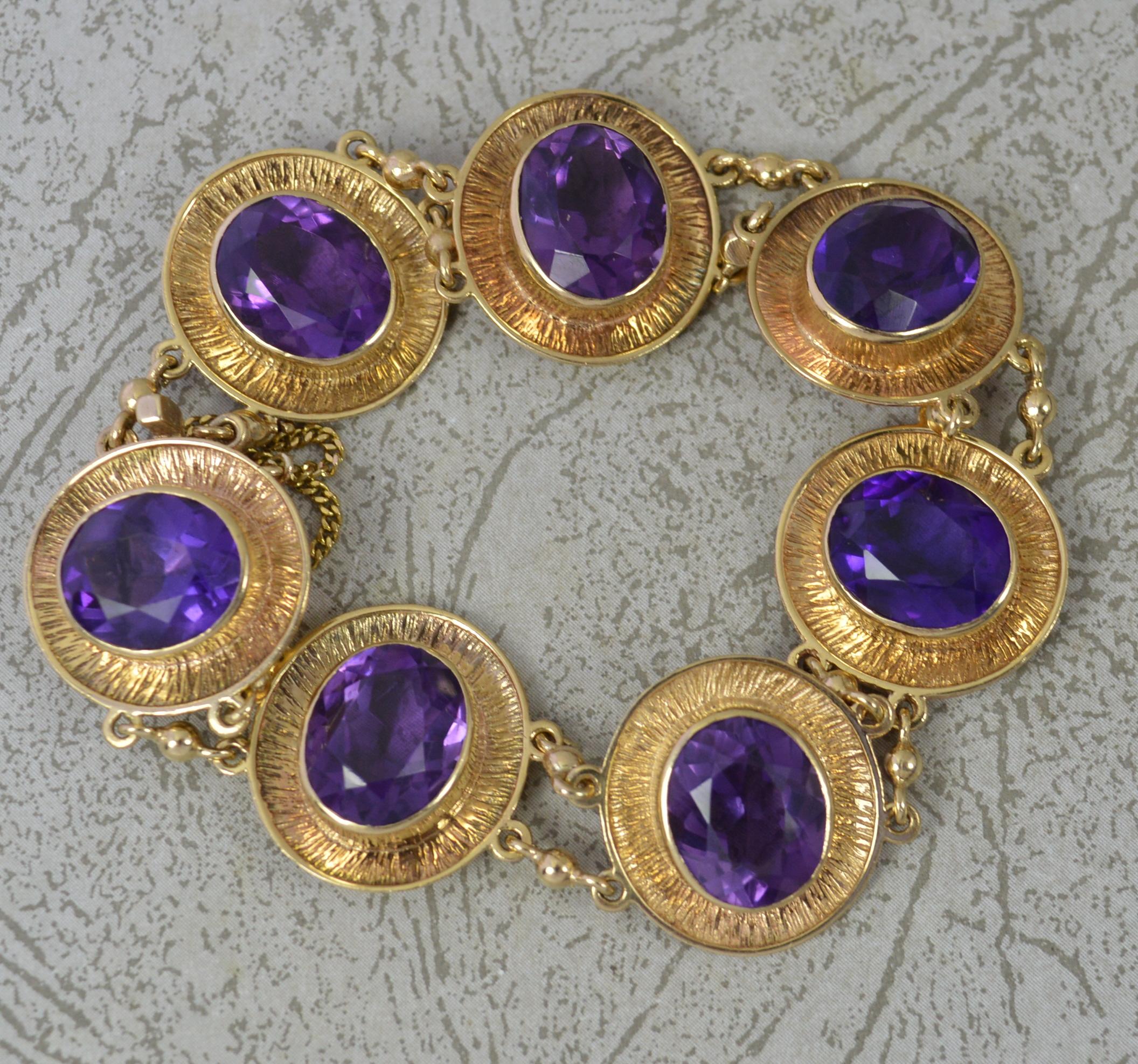 A superb vintage bracelet.
Solid 9 carat yellow gold example.
Designed with seven large oval cut purple amethyst stones, full bezel settings with a bark type finish surround. 
9mm x 12mm amethyst. 17mm x 19mm panels.

CONDITION ; Very good for age.