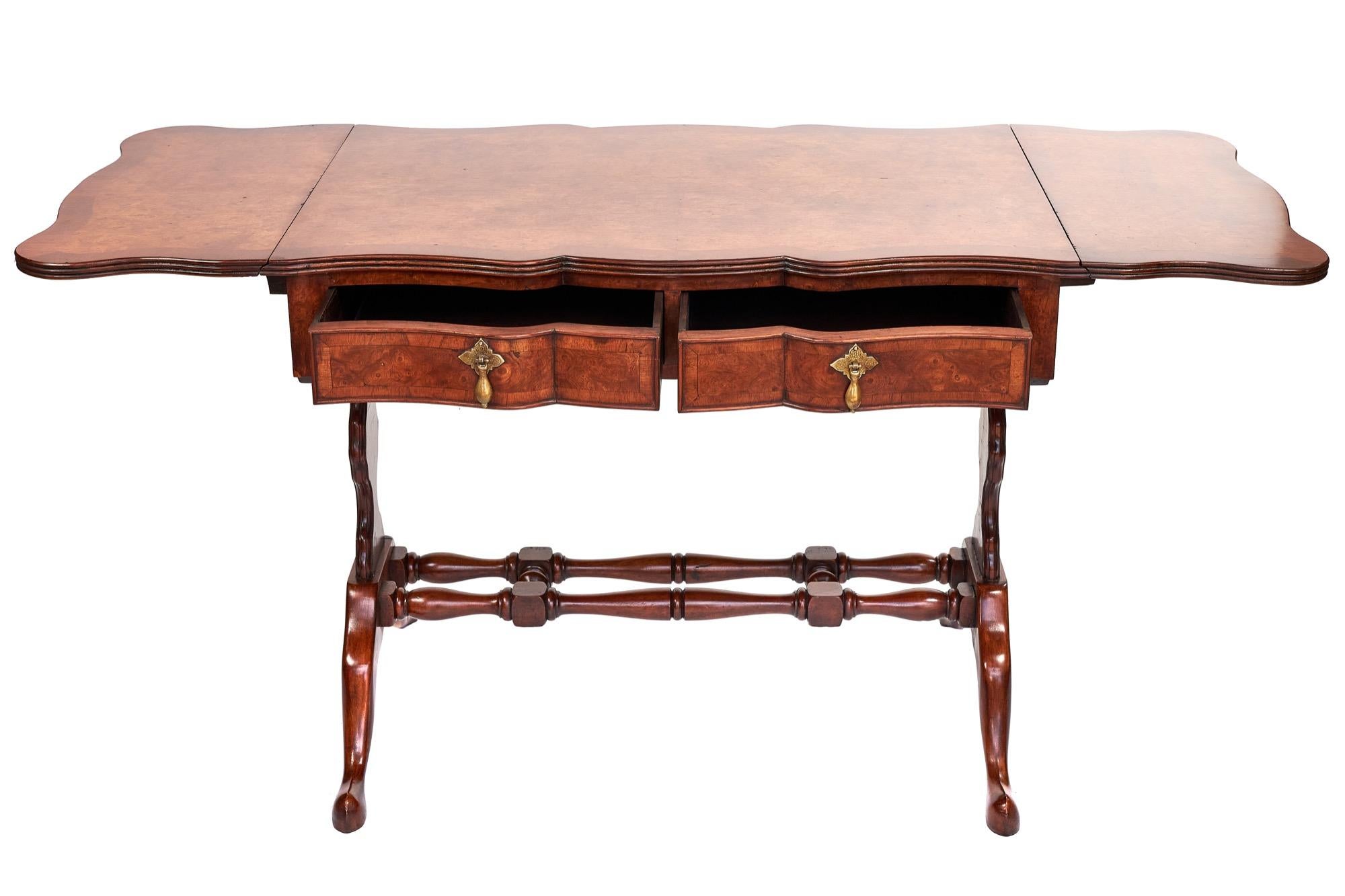 This is an antique burr walnut centre table of exceptional quality with a beautiful burr walnut top with pretty walnut crossbanding. It boasts two elegant shaped front drawers with oak linings, two dummy drawers to the rear. Dual turned cross
