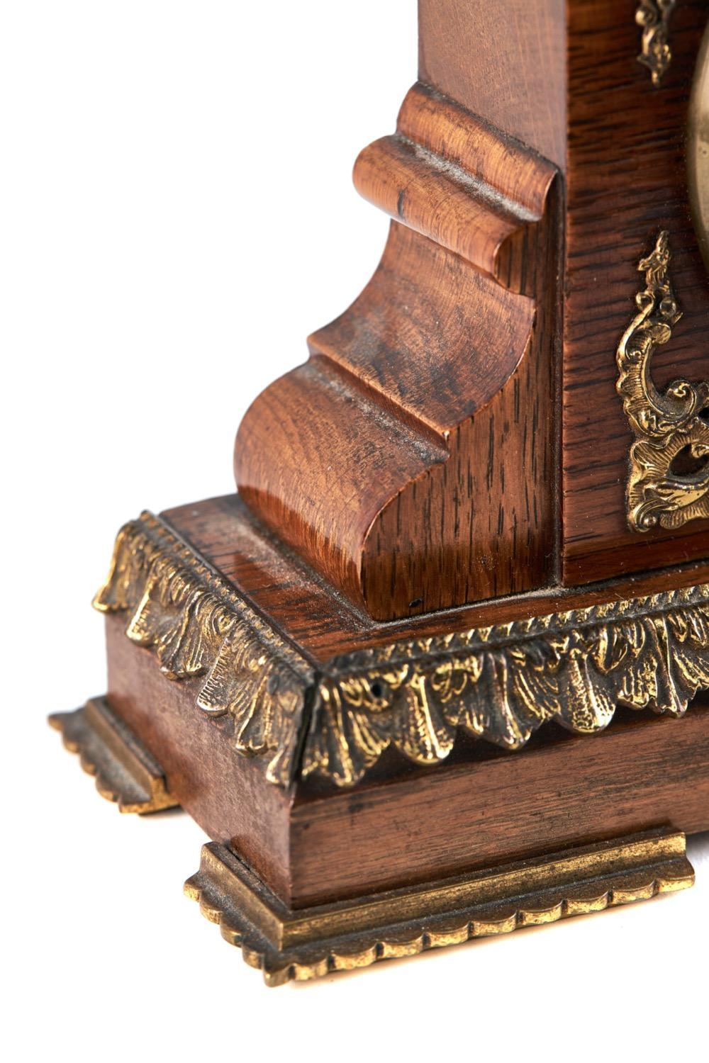 This is a quality antique desk clock and barometer set having a quality oak case with ornate brass mounts. The two faces divided by a thermometer. 8 day movement, French, original key.