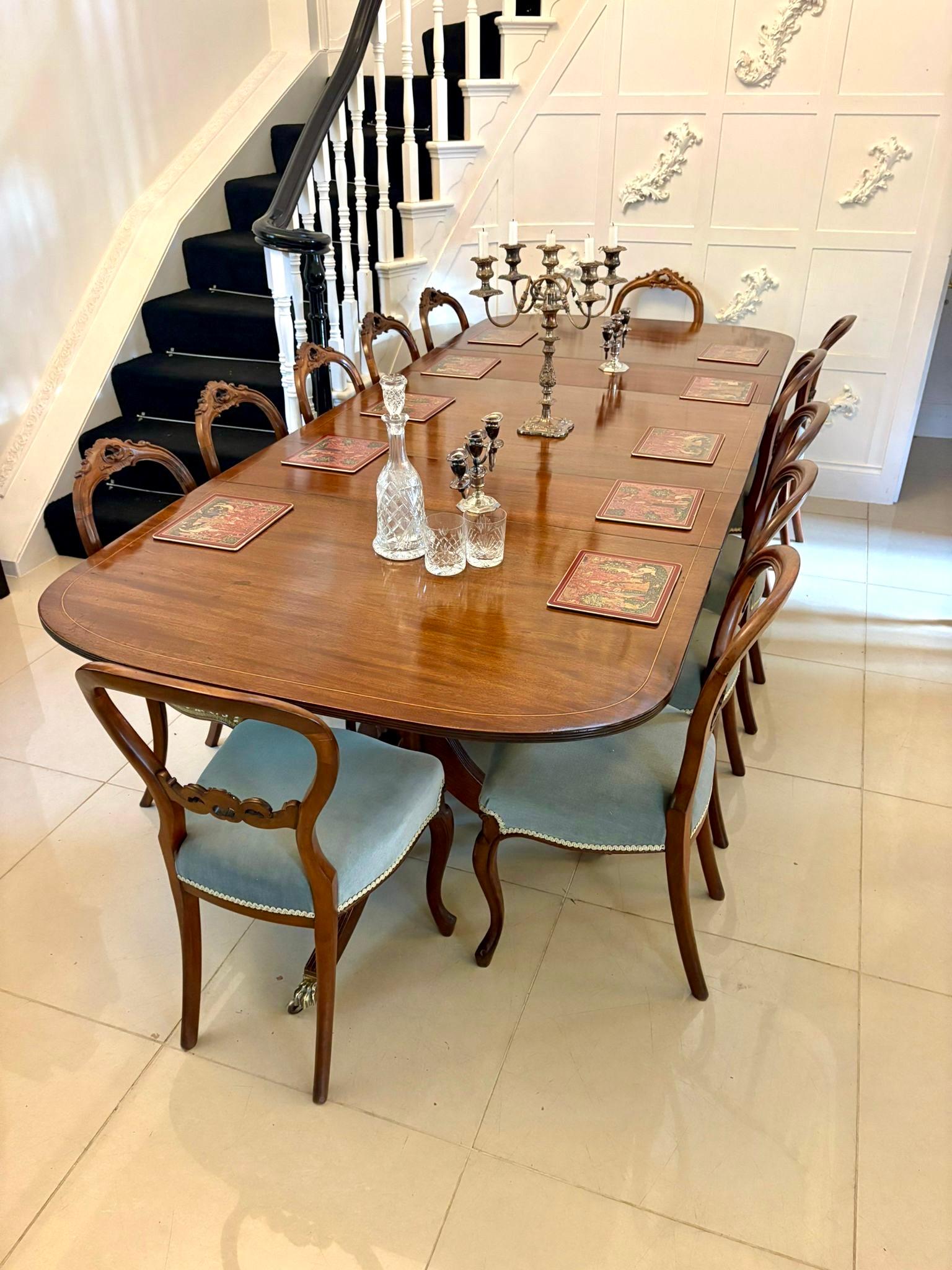 A superb Edwardian triple-pedestal dining table in beautifully figured mahogany, finely string-inlaid with satinwood and displaying the elegant, refined lines characteristic of the period’s revival of earlier Georgian and Regency forms. The rounded