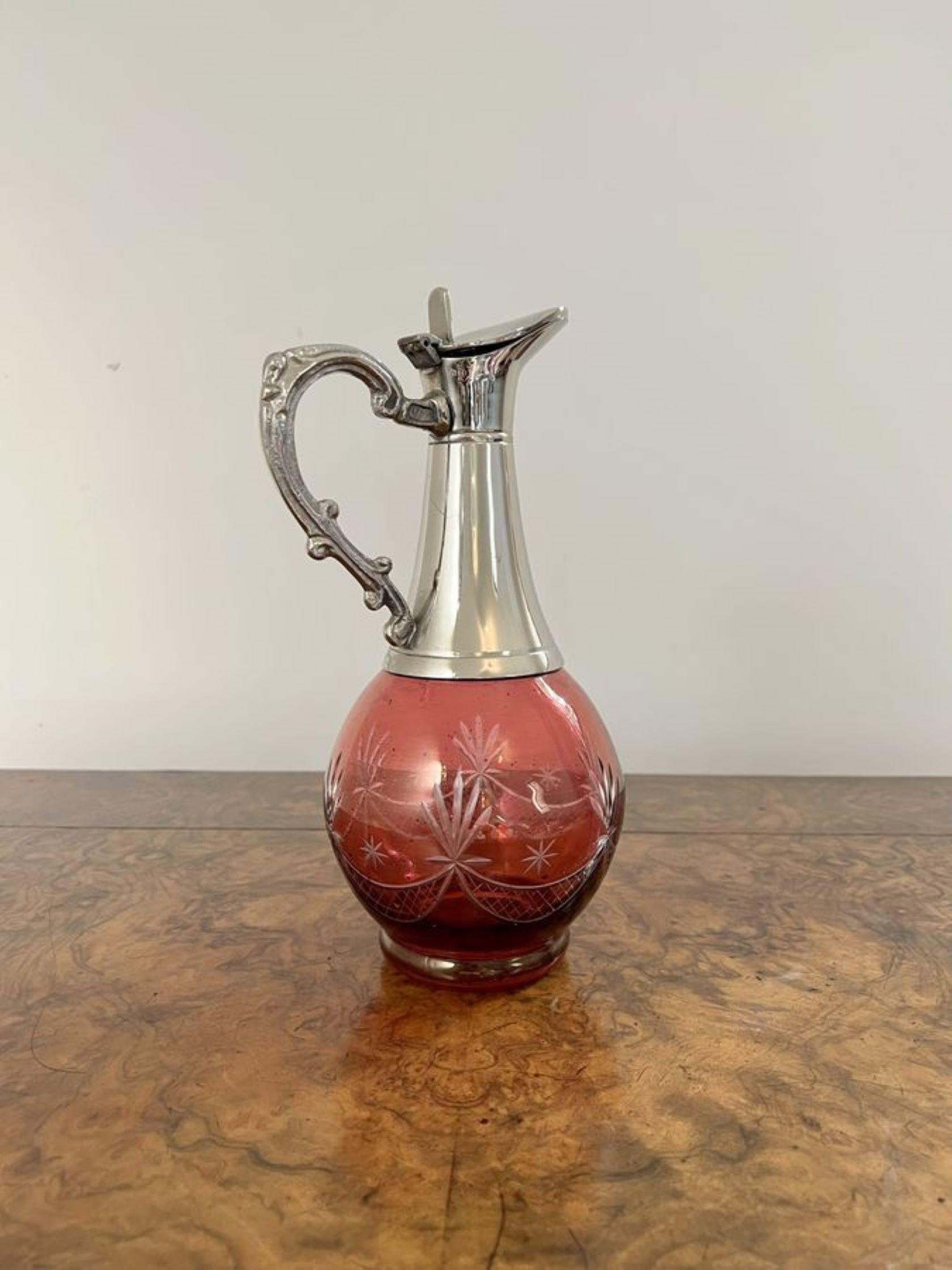 Quality antique Edwardian cranberry glass wine decanter having a wonderful cranberry glass decanter etched with stars with a silver plated neck and a quality ornate shaped handle.

D. 1910 