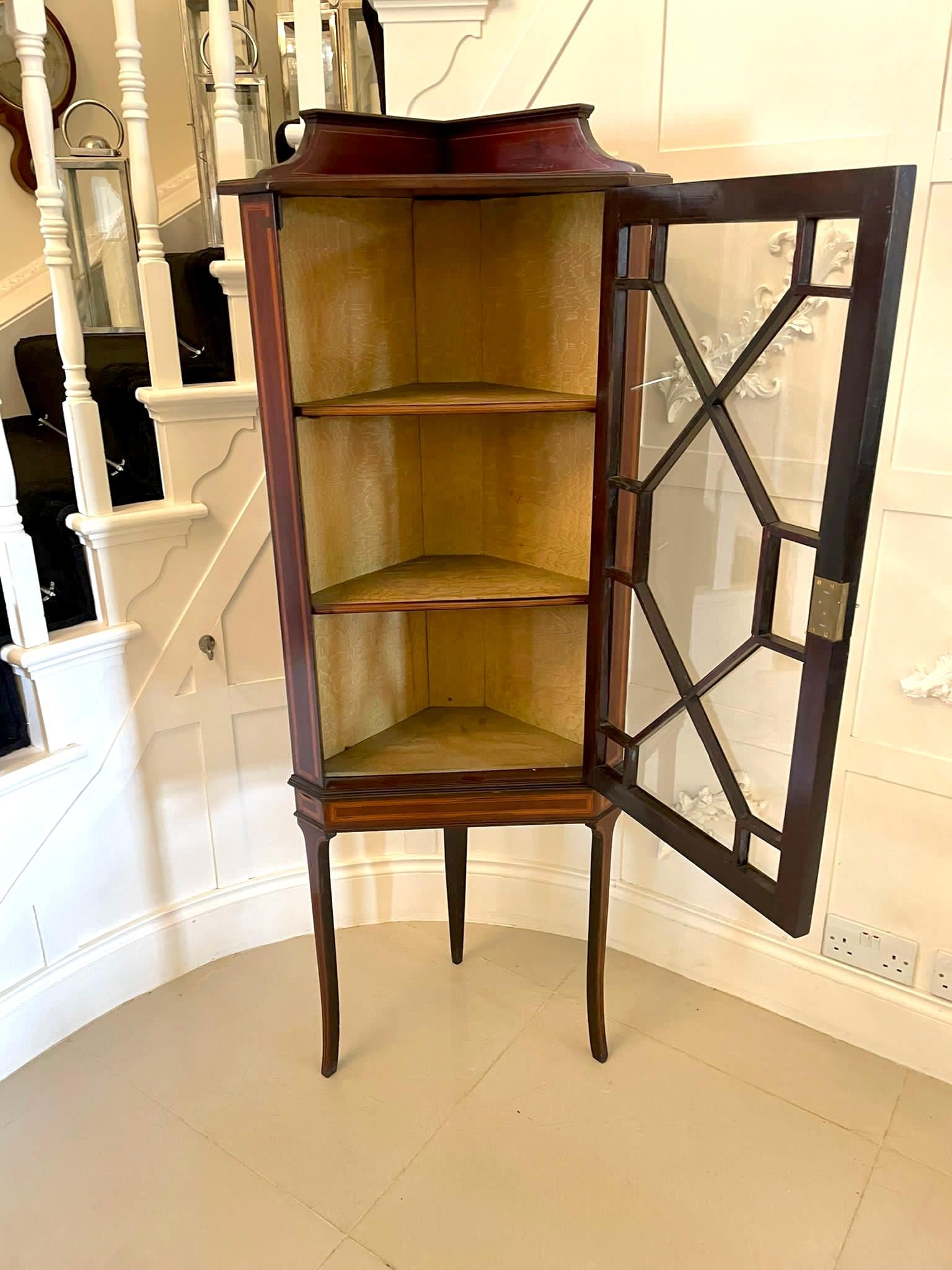 Quality antique Edwardian inlaid mahogany corner display cabinet having an attractive mahogany inlaid gallery and top above a single astral glazed door opening to reveal two shelves standing on elegant mahogany inlaid shaped legs.

A charming