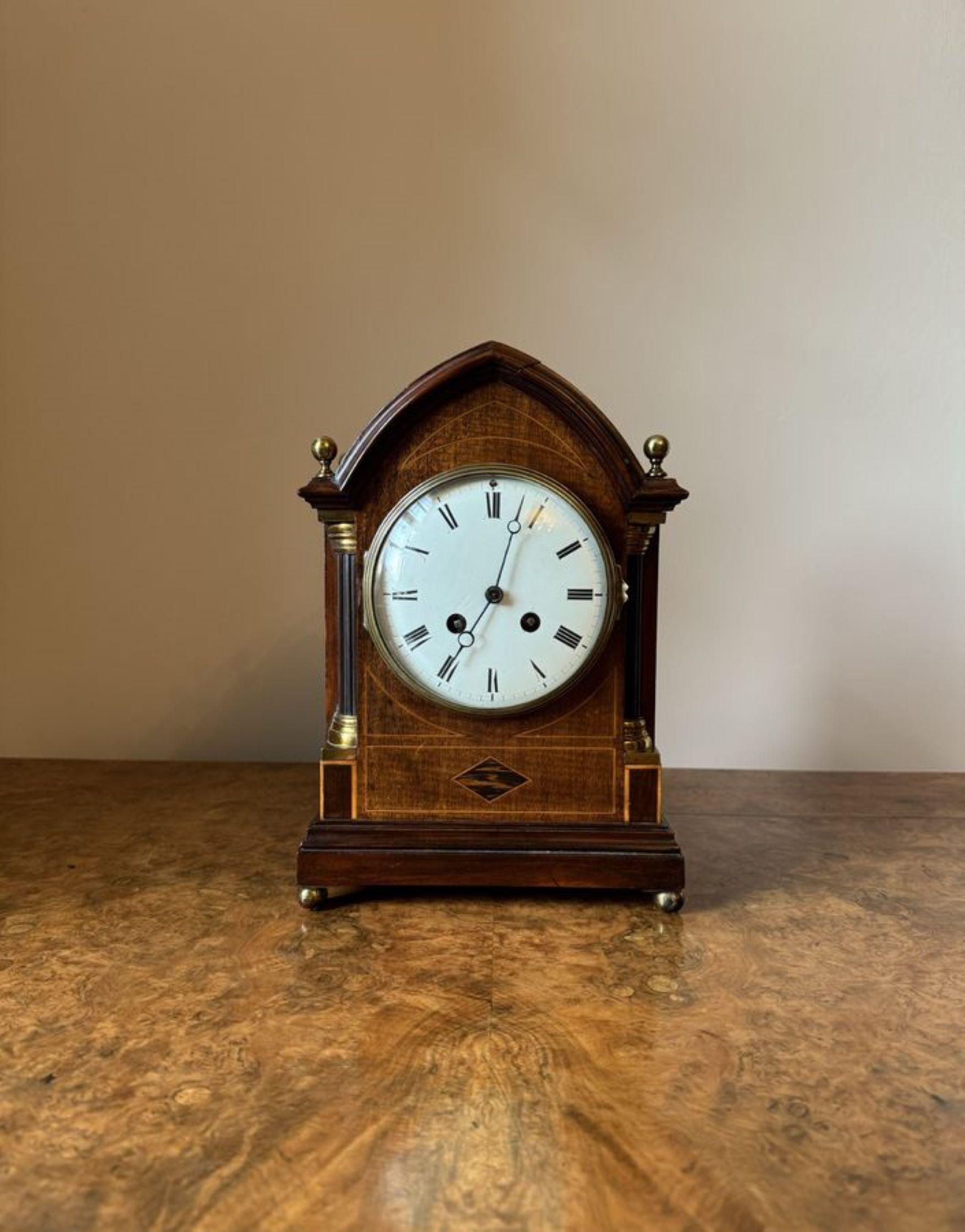 Quality antique Edwardian mahogany inlaid bracket clock, having a quality mahogany arched top case with satinwood inlay reeded columns with the original brass finales and original brass ball feet, having a circular porcelain dial with the original