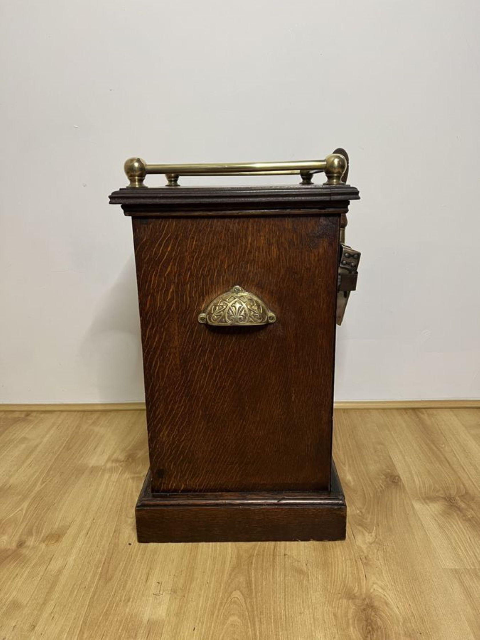 Quality antique Edwardian oak and brass coal purdonium with a brass gallery to the top and two ornate brass carrying handles to the sides, a brass knob to the front opening to reveal a compartment for coal with the original removable tin liner, a