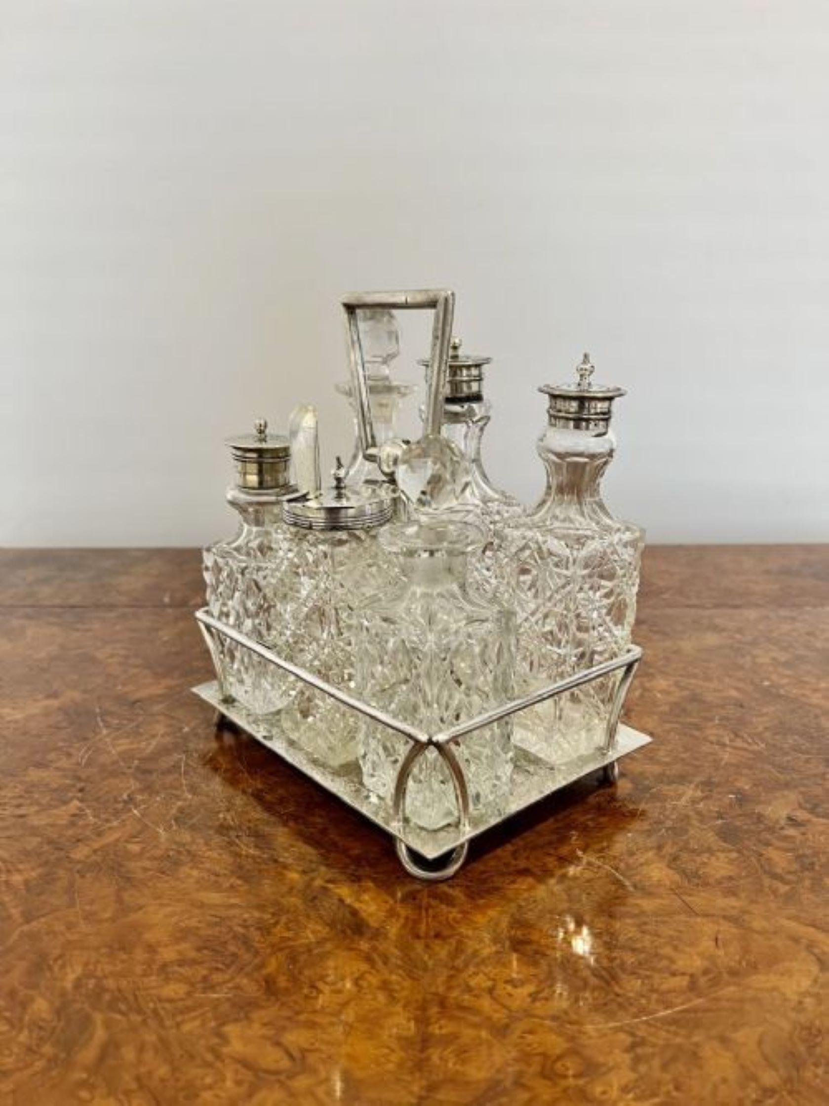 Antique Edwardian silver plated cruet set having a quality silver plated stand with a shaped handle with six original cut glass bottles with silver plated tops for salt, pepper, vinegar, mustard and oils.
