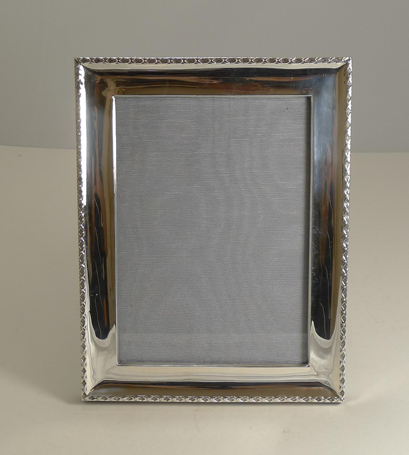 A handsome and stylish Edwardian photograph frame hallmarked for Birmingham 1909, a true antique example.

The back is made from solid English oak with a folding easel stand allowing the photograph to sit either upright or in a landscape