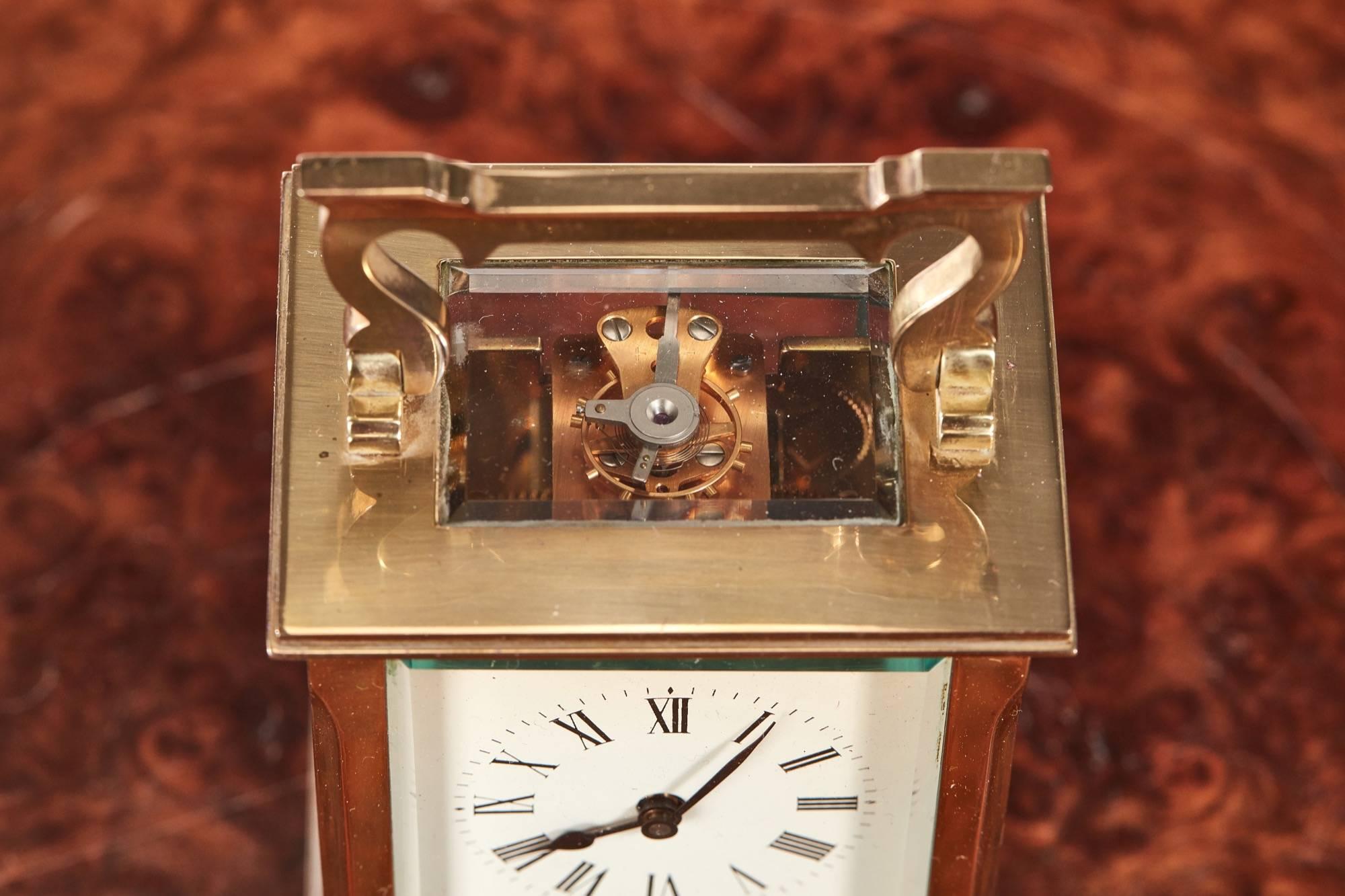 Quality antique French brass carriage clock with a shaped handle, lovely porcelain dial and bevelled edge glass to each side 8 day French movement in working order, original key.