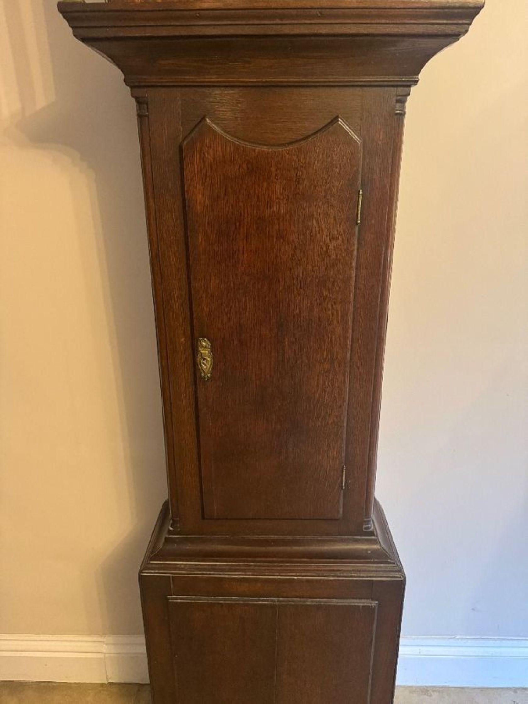 Antico orologio a cassa lunga di qualità di Oak Oak III, con un antico orologio a cassa lunga di qualità di George III con la parte superiore della cappa intagliata a volute con un finale centrale sopra un quadrante ad arco dipinto con una scena di