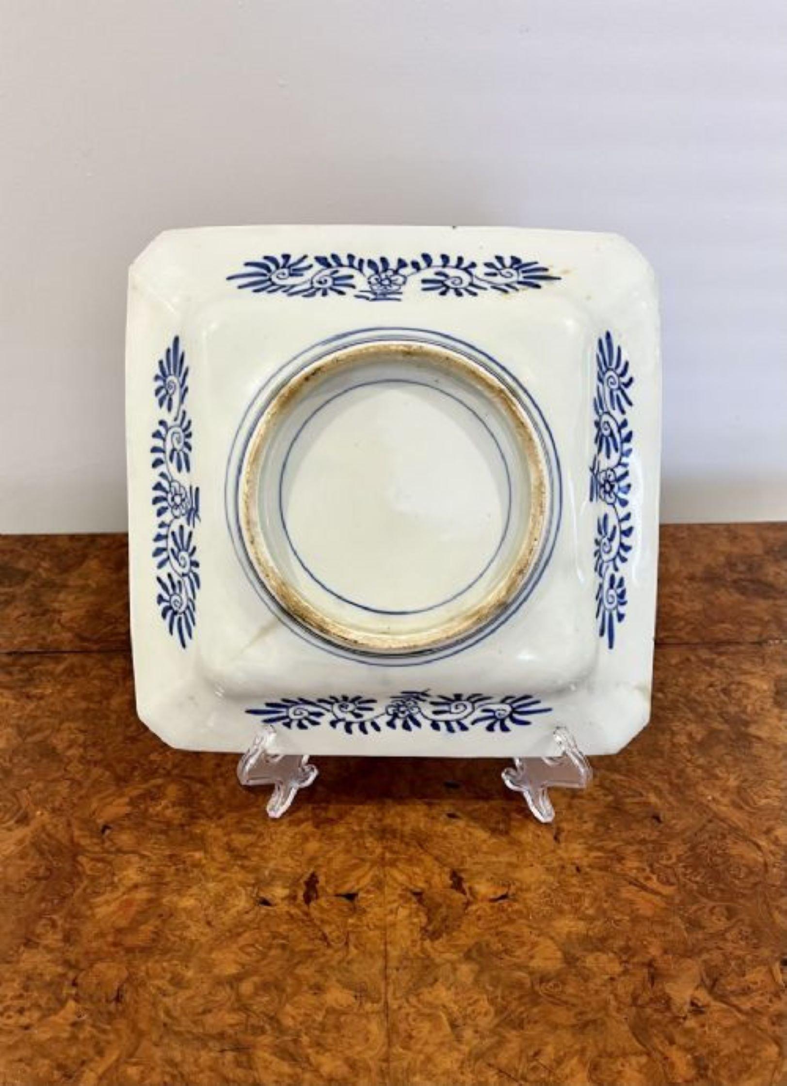 Hochwertiger, antiker, handgemalter, japanischer, großer, quadratischer Imari-Teller mit hochwertigen, handgemalten Tafeln, mit einer Vase mit Blumen und Blättern in der Mitte, in den wunderbaren Farben Rot, Blau, Orange und Weiß.

