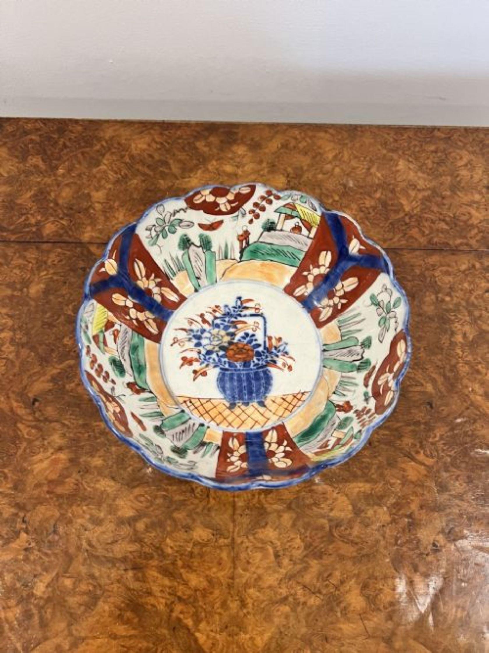 Quality antique Japanese Imari bowl having a scalloped shape edge, to the centre a basket of flowers surrounded by wonderful hand painted panels decorated with people, houses, birds, flowers and leaves in fantastic red, blue, green and white