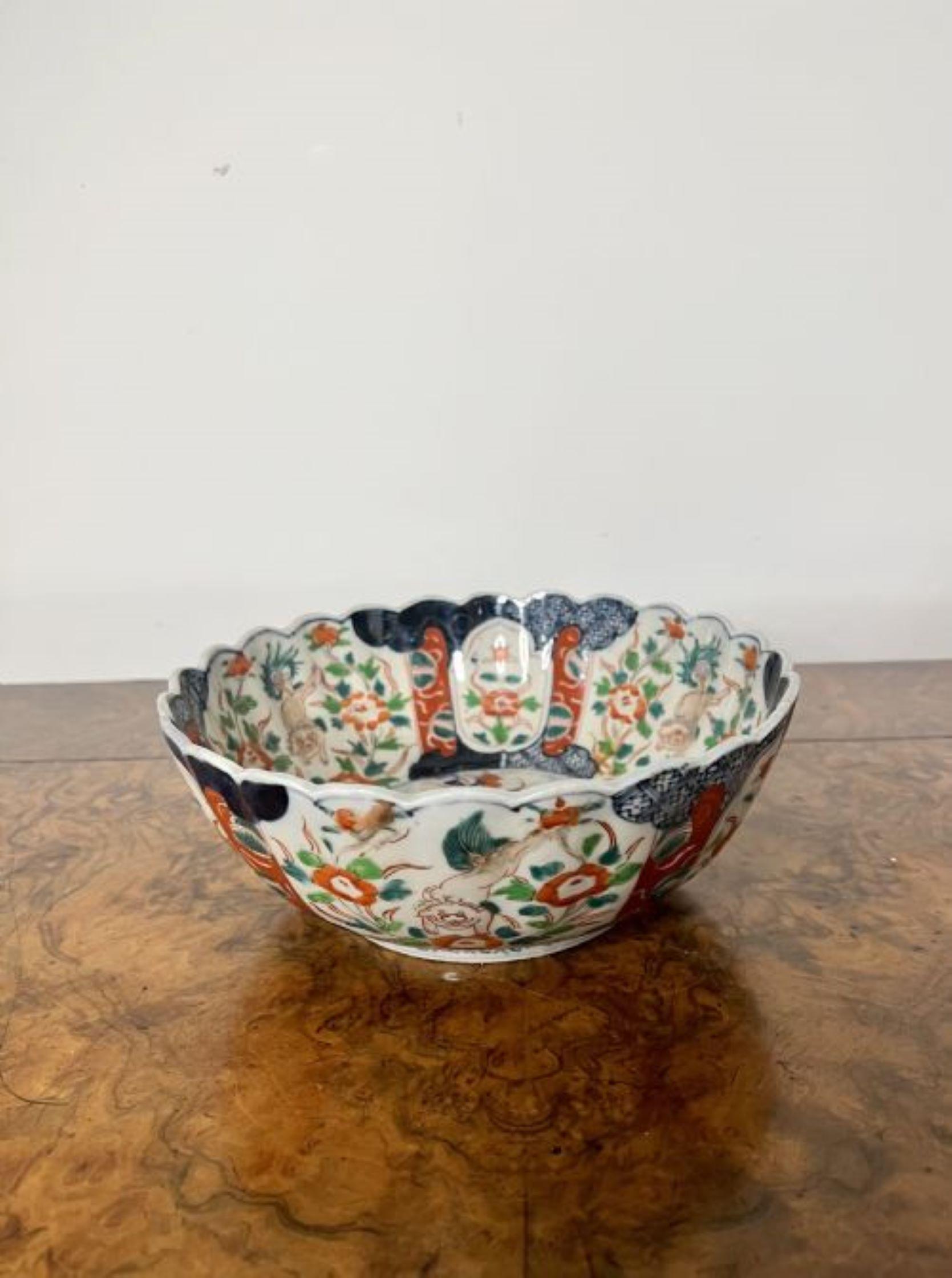 Quality antique Japanese Imari bowl having a scalloped shape edge, to the centre a basket of flowers surrounded by wonderful hand painted panels decorated with flowers, leaves and scrolls in fantastic red, blue, green and white colours.
