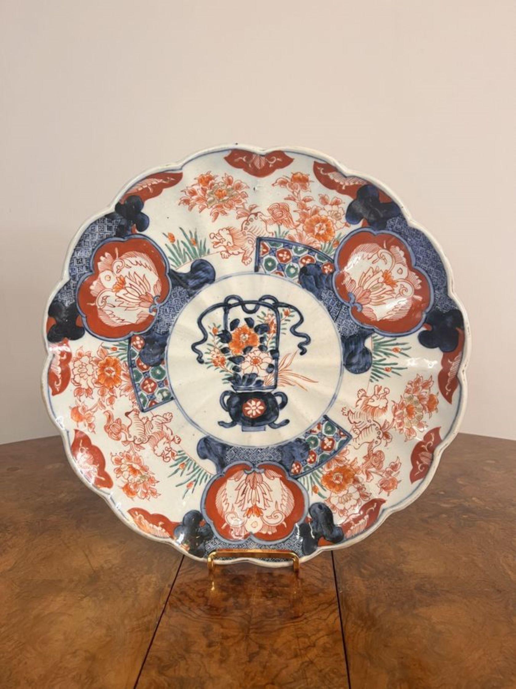 Hochwertiger antiker japanischer Imari-Teller, der in der Mitte mit einem Blumenkorb verziert ist, umgeben von handgemalten Blumen, Blättern, Bäumen und Mustern in blauen, roten, grünen und weißen Farben.

D. 1900