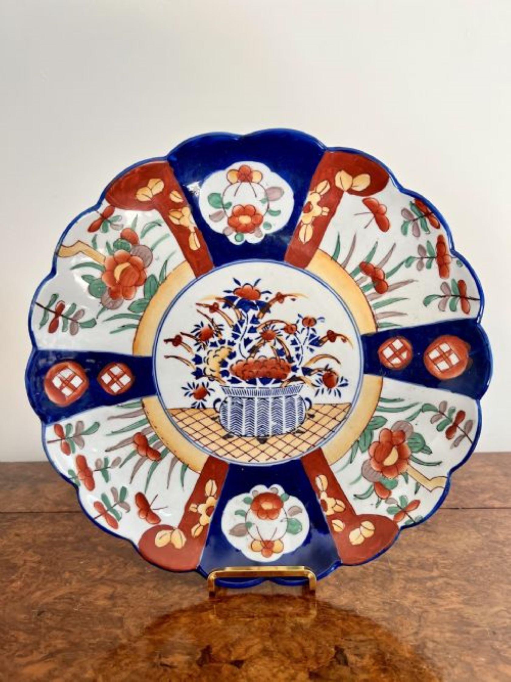 Quality antique Japanese imari scalloped shaped edge plate having a quality Japanese imari plate with a scalloped shape edge, hand painted decoration with a basket of flowers to the centre surrounded by panels with flowers, leaves and pattens in