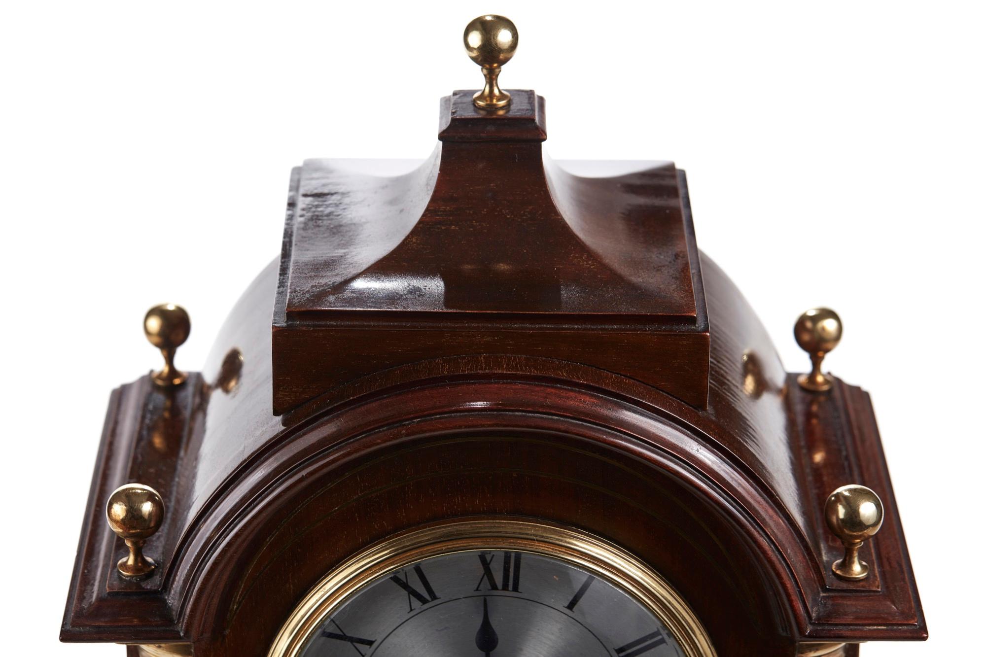 Quality antique mahogany brass inlaid 8 day mantel (fireplace) Clock having a lovely shaped top with 5 brass finals. Brass inlaid columns, round silver dial on a shaped plinth with brass feet. Perfect working order, original key.