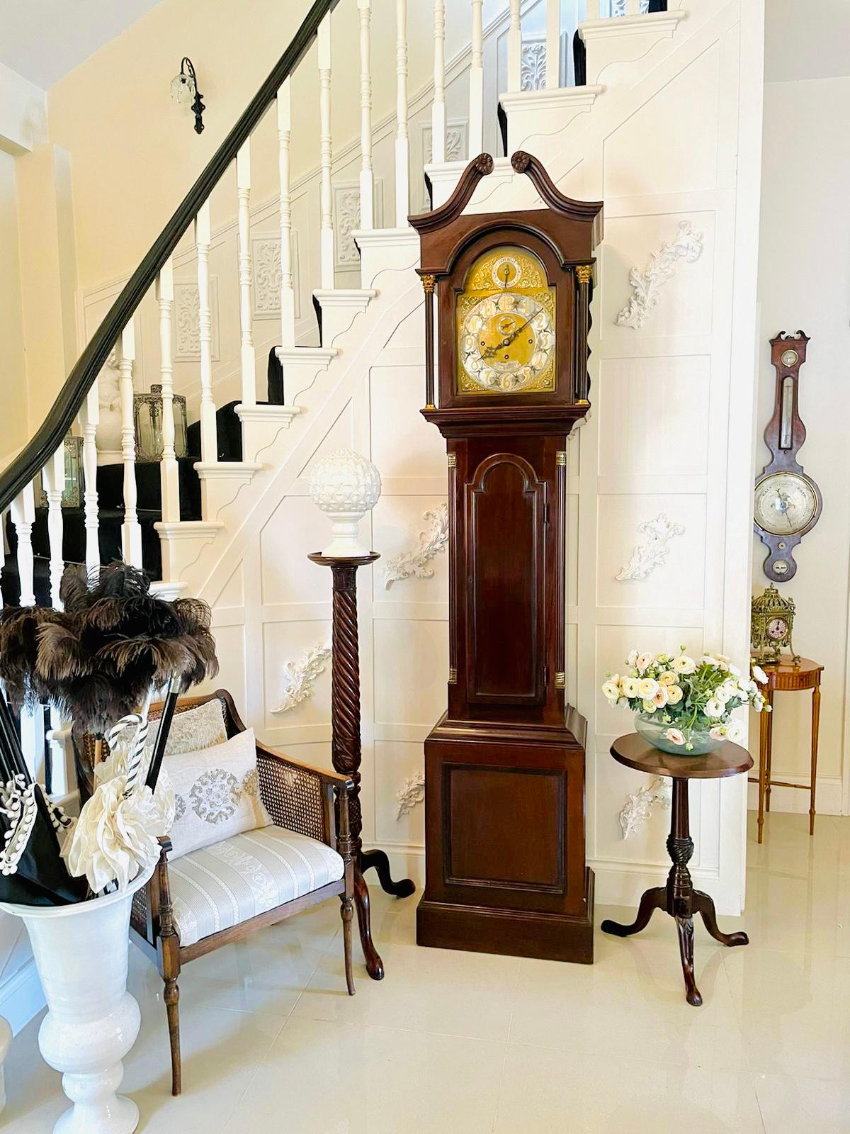 Quality antique mahogany eight day Grandfather clock on eight bells having a very attractive mahogany case with an elegant carved swan neck pediment and arched door to the hood flanked by turned columns, gilded brass Corinthian capitals and brass