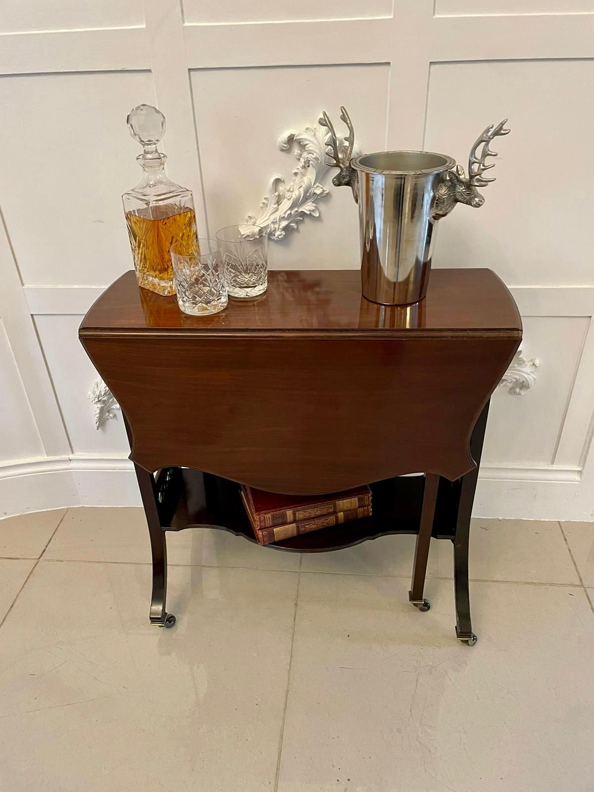 Quality antique mahogany Sutherland table boasting a fabulous mahogany top with two shaped drop leaves. It is supported by beautiful fret-work ends and has square swing out legs with lovely upswept legs, it is united by a shaped stretcher and has
