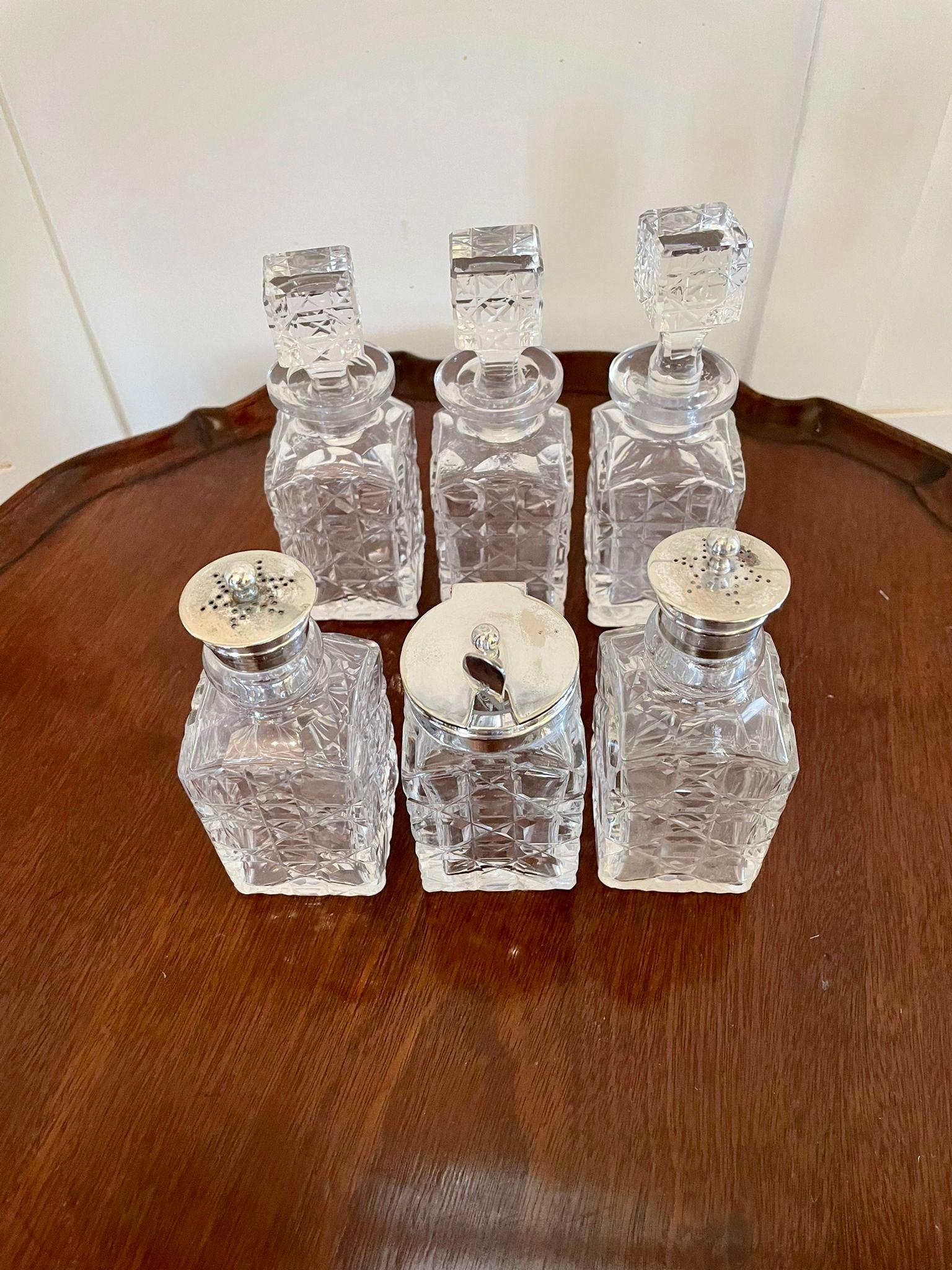Quality antique silver plated six bottle cruet set consisting of a quality silver plated stand with six cut glass condiment bottle. The stand having a round carrying handle to the top, shaped shield to the sides and standing on ball feet.

An