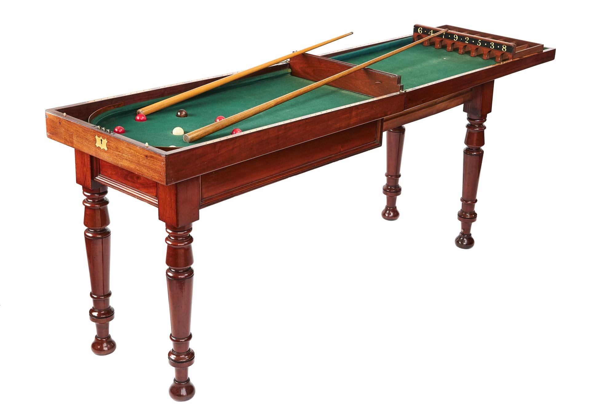 Quality antique Victorian bagatelle games table.
The mahogany table base extends to hold the mahogany fold-over top, original baize with painted numbered scoring cups and inlaid peg scoring holes each side. Comes with set of balls and 2 cues. The